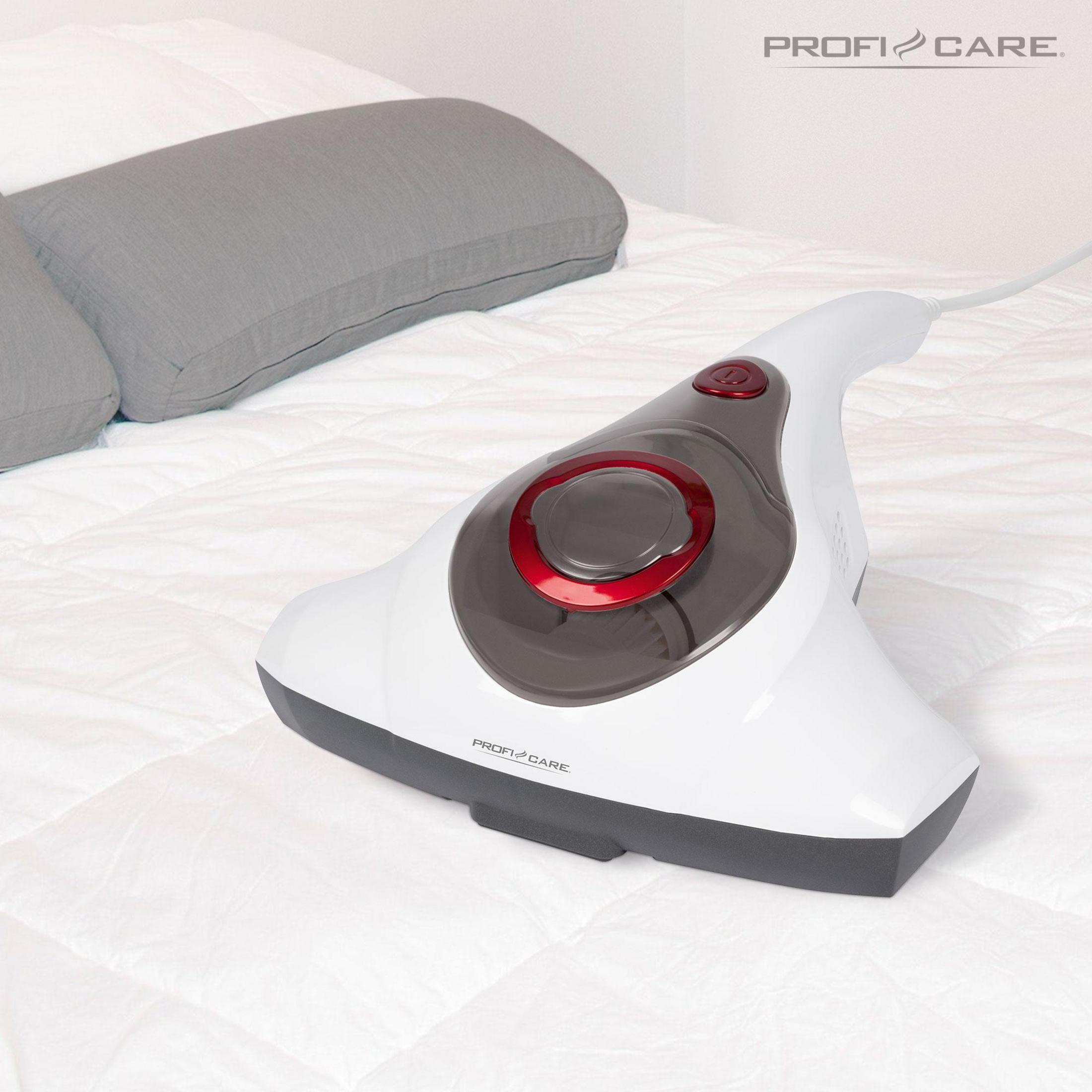 Biały odkurzacz ręczny na łóżku, szara poduszka w tle.