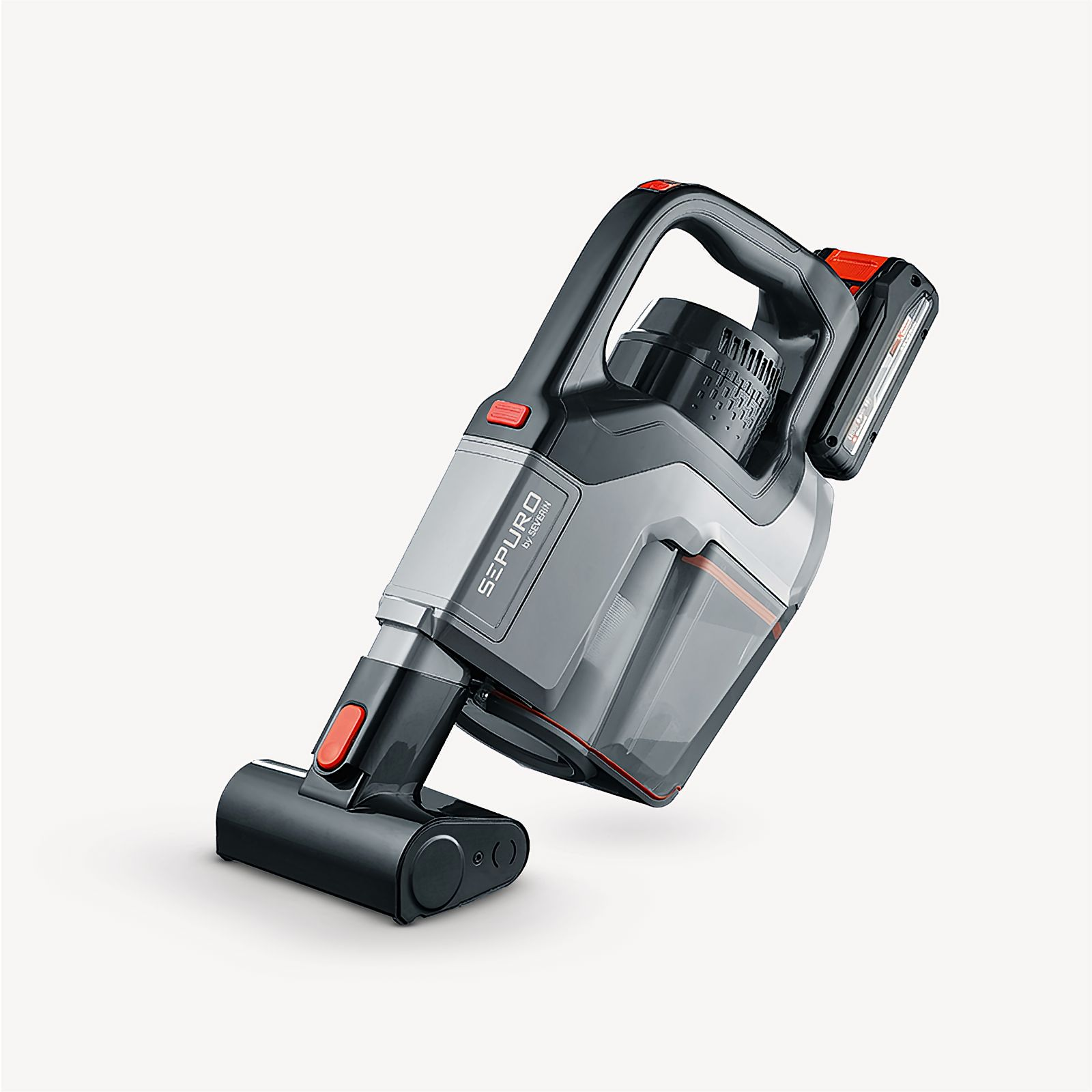 Aspirapolvere portatile, grigio con dettagli rossi. Ha un contenitore trasparente. Sfondo bianco.
