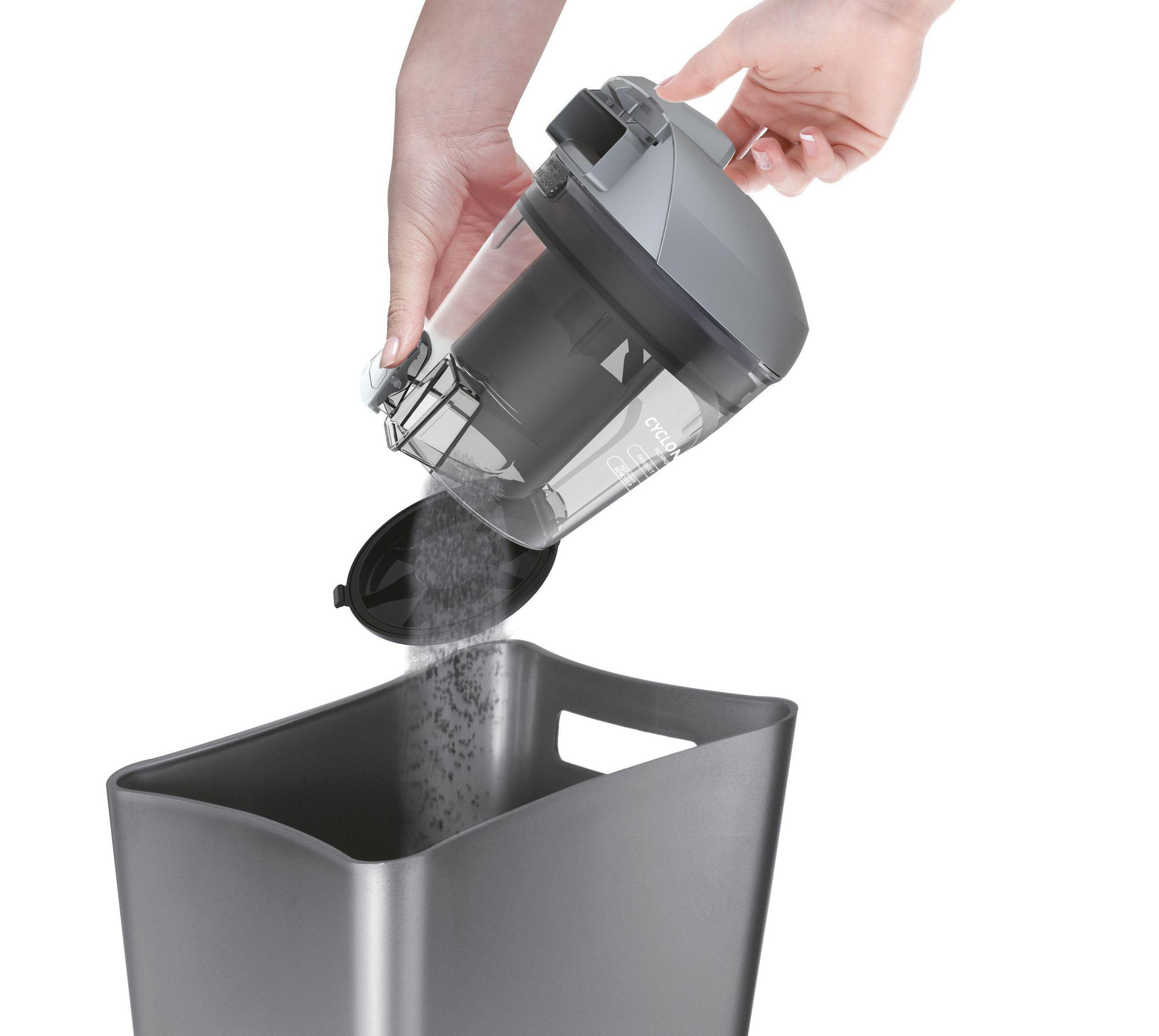 Ręce opróżniające pojemnik na kurz odkurzacza do ciemnoszarego kosza na śmieci.