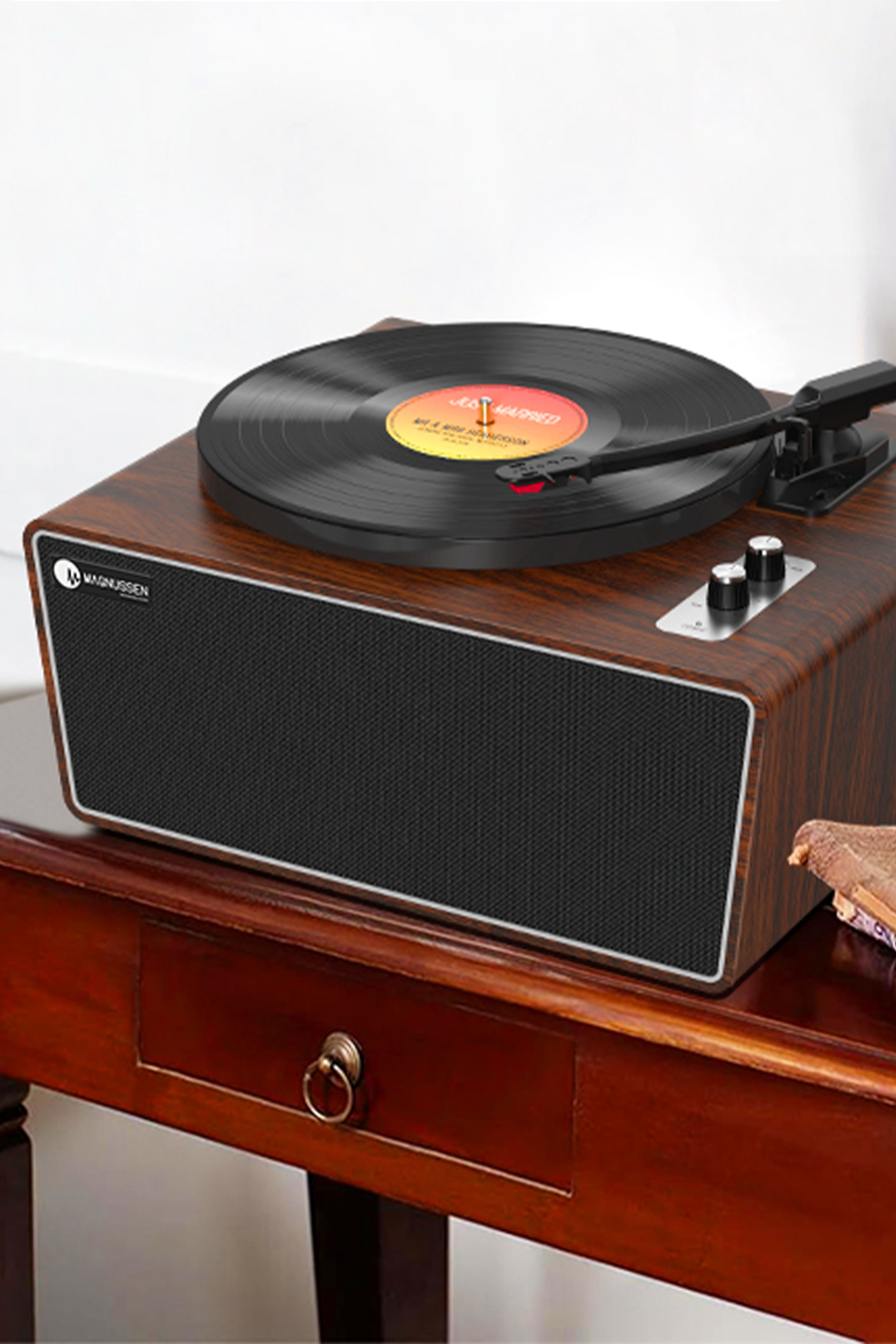 Un tocadiscos de madera con un disco de vinilo negro encima. Una mesa de madera oscura en el fondo.