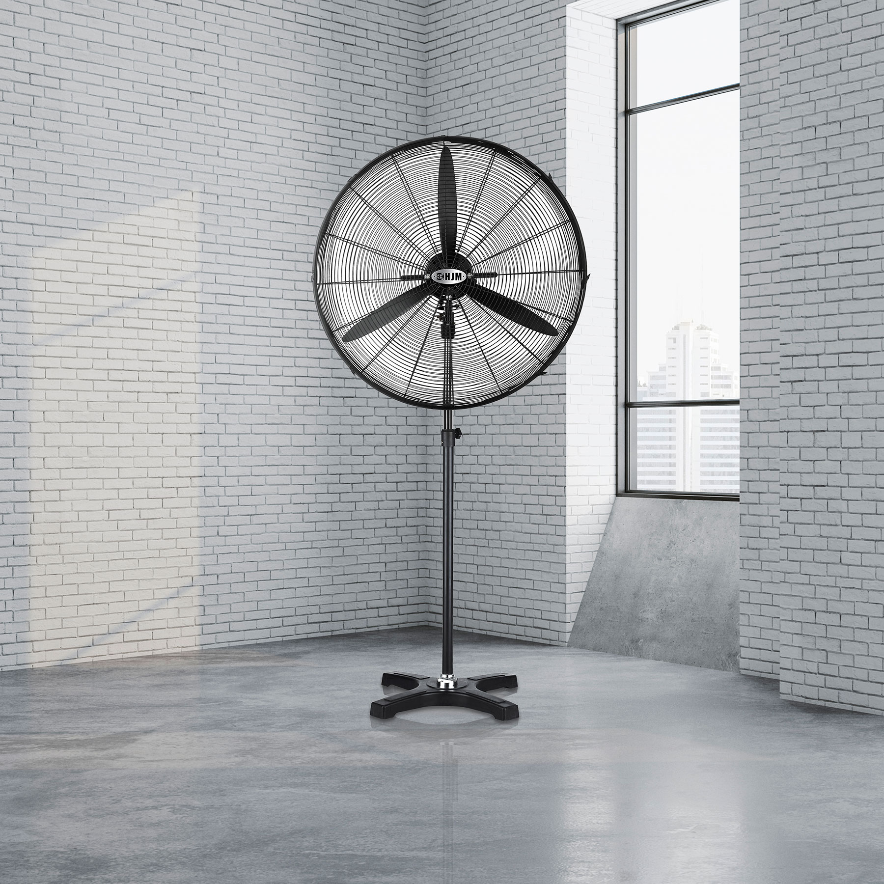 Ventilador industrial negro sobre un soporte en una habitación blanca con pared de ladrillo. Ventana a la derecha.