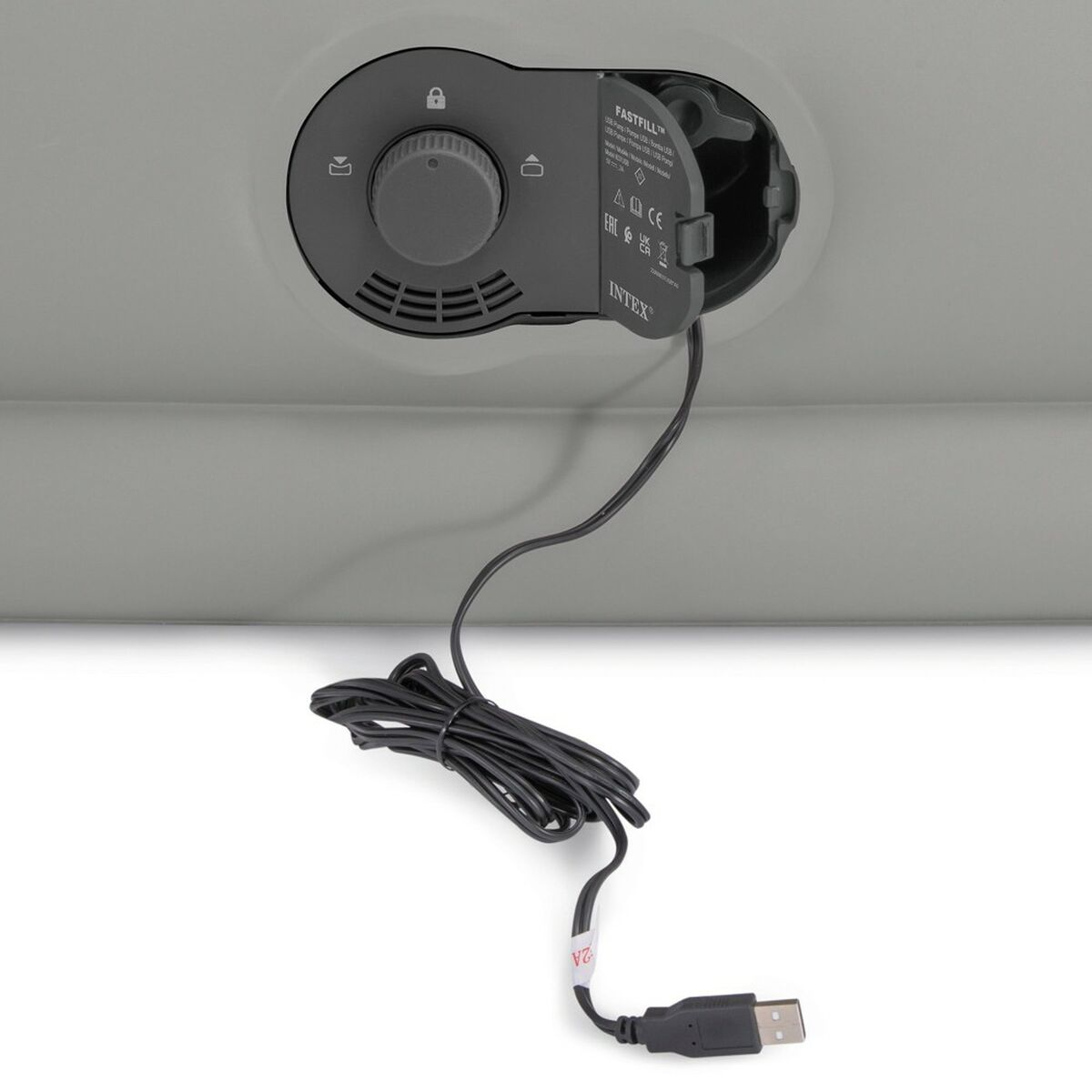 Ein graues aufblasbares Objekt mit Bedienfeld und USB-Kabel, auf weißem Hintergrund.