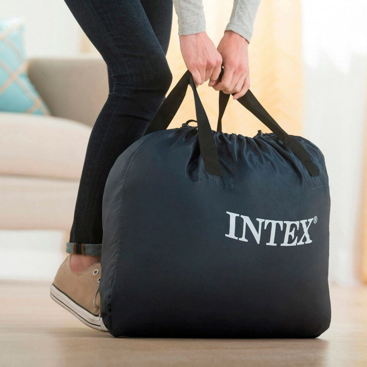 Osoba trzymająca czarną torbę z białym napisem "INTEX".