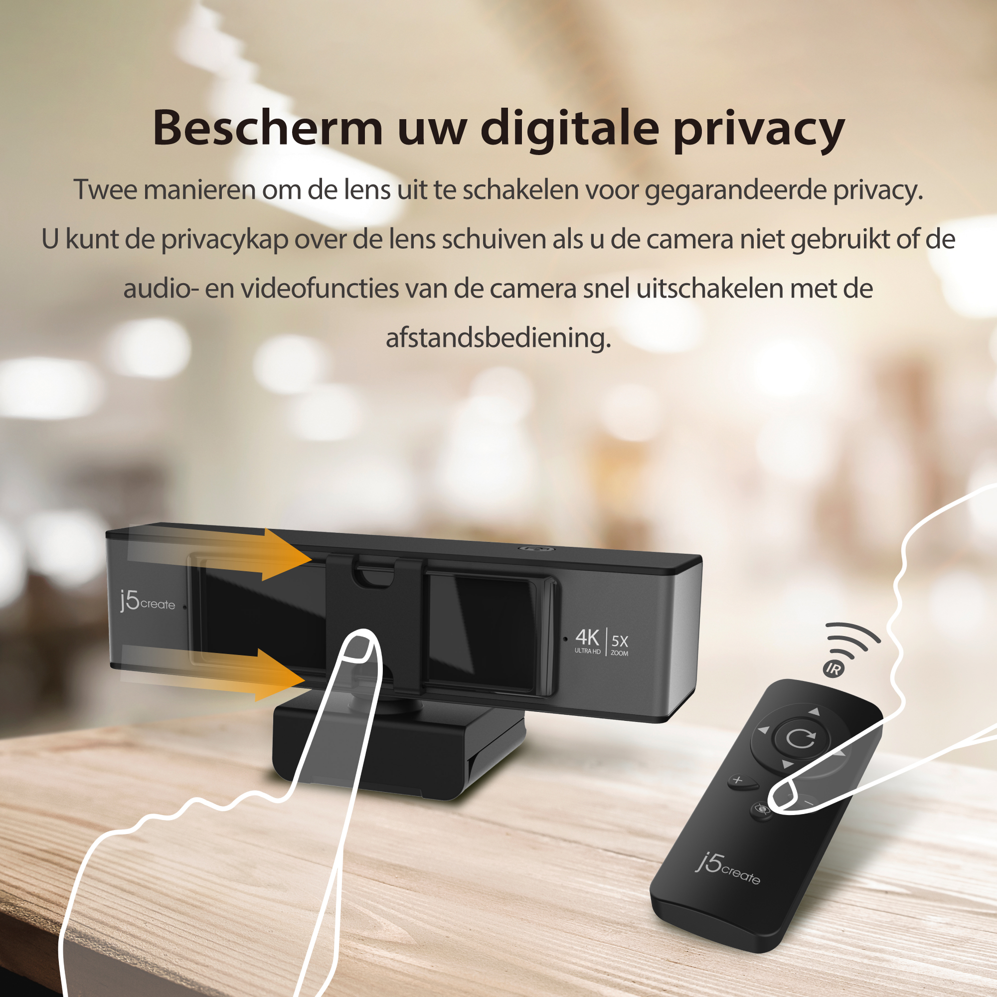 Kamera internetowa z pilotem. Czarna kamera na drewnianym stole. Pomarańczowe strzałki. Tekst po niderlandzku. Rozmyte tło.