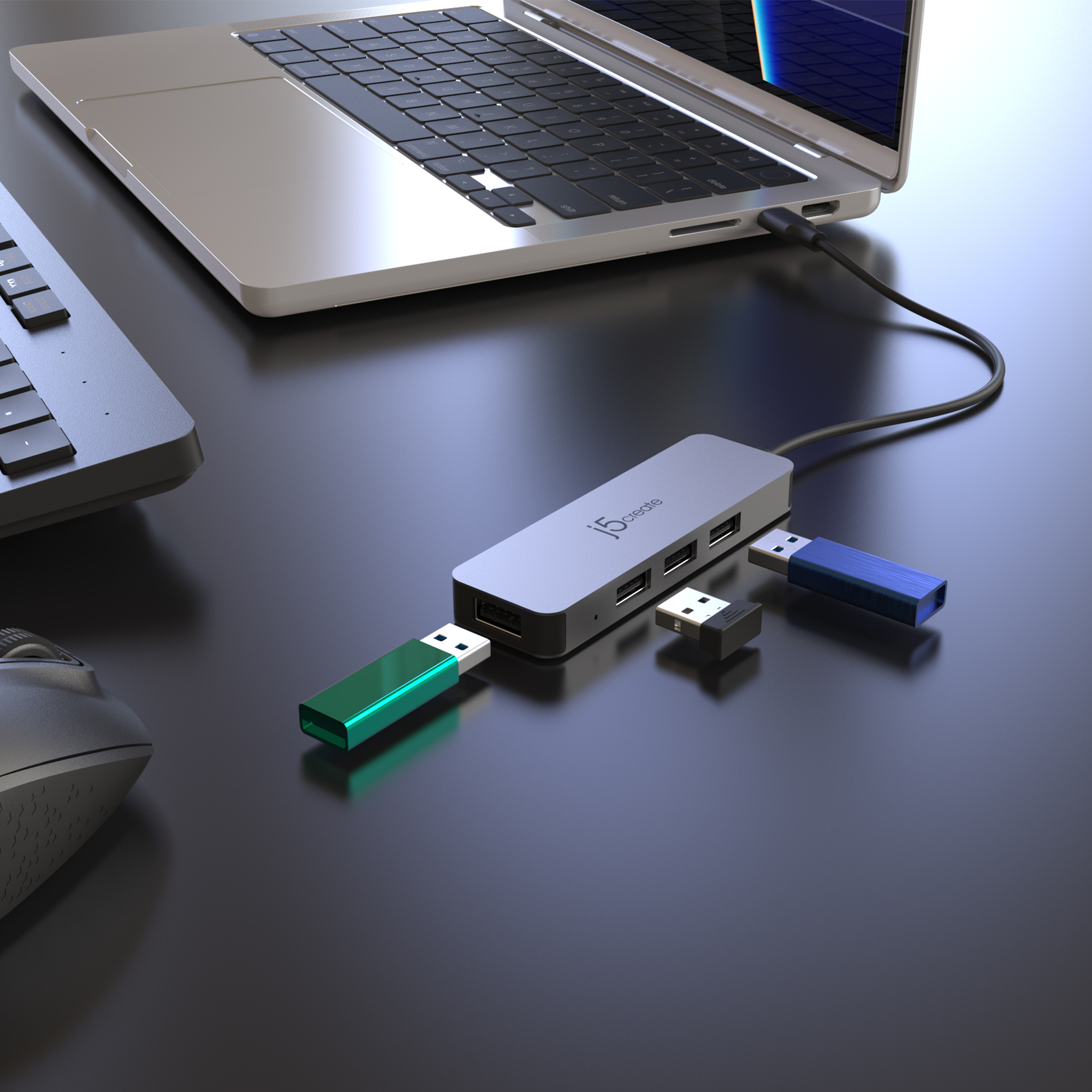 Laptop, USB-Hub und USB-Laufwerke auf schwarzer Oberfläche. Der Hub hat USB-Anschlüsse.