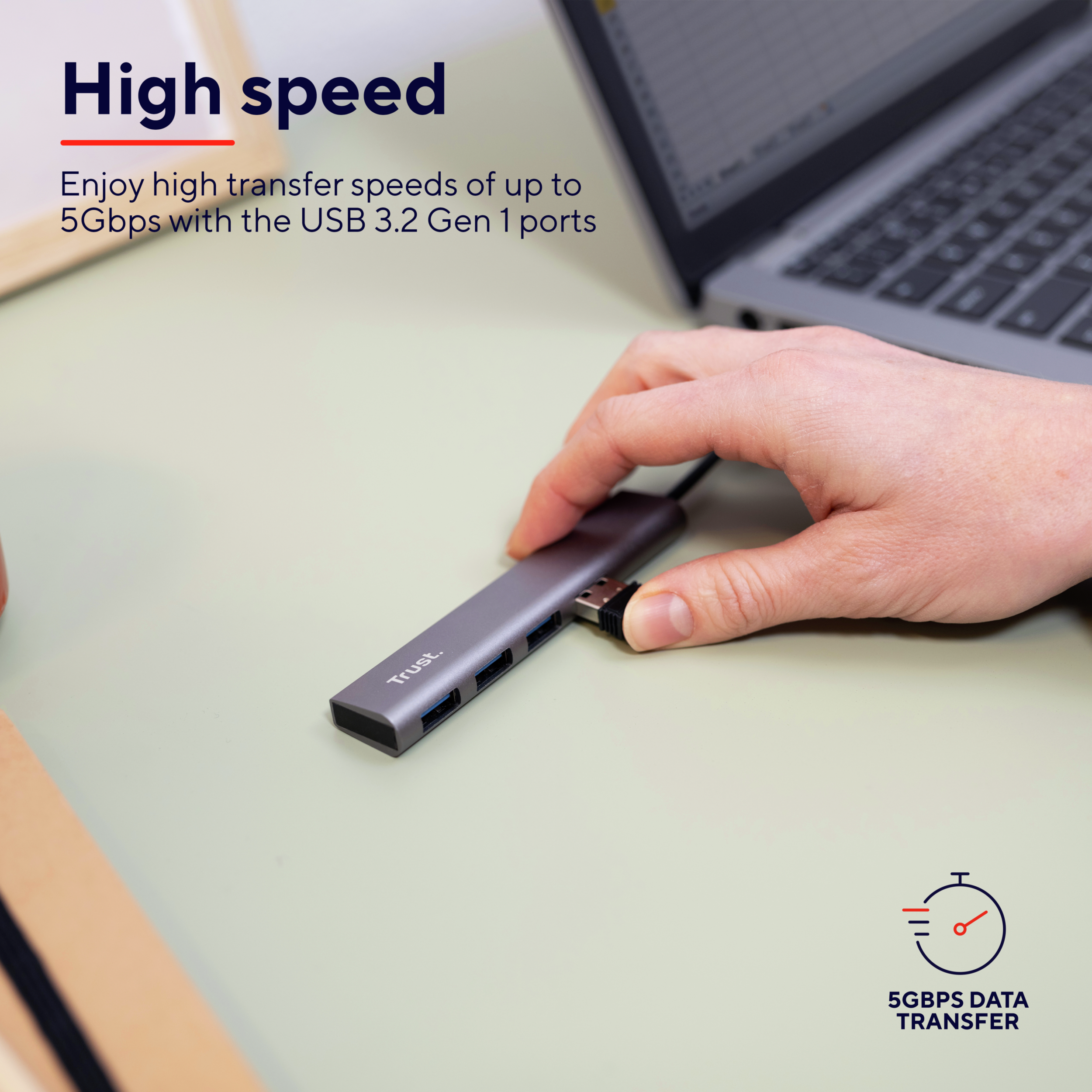 Een hand die een USB-hub gebruikt. De hub is grijs en heeft meerdere poorten. Tekst: 'High speed'.