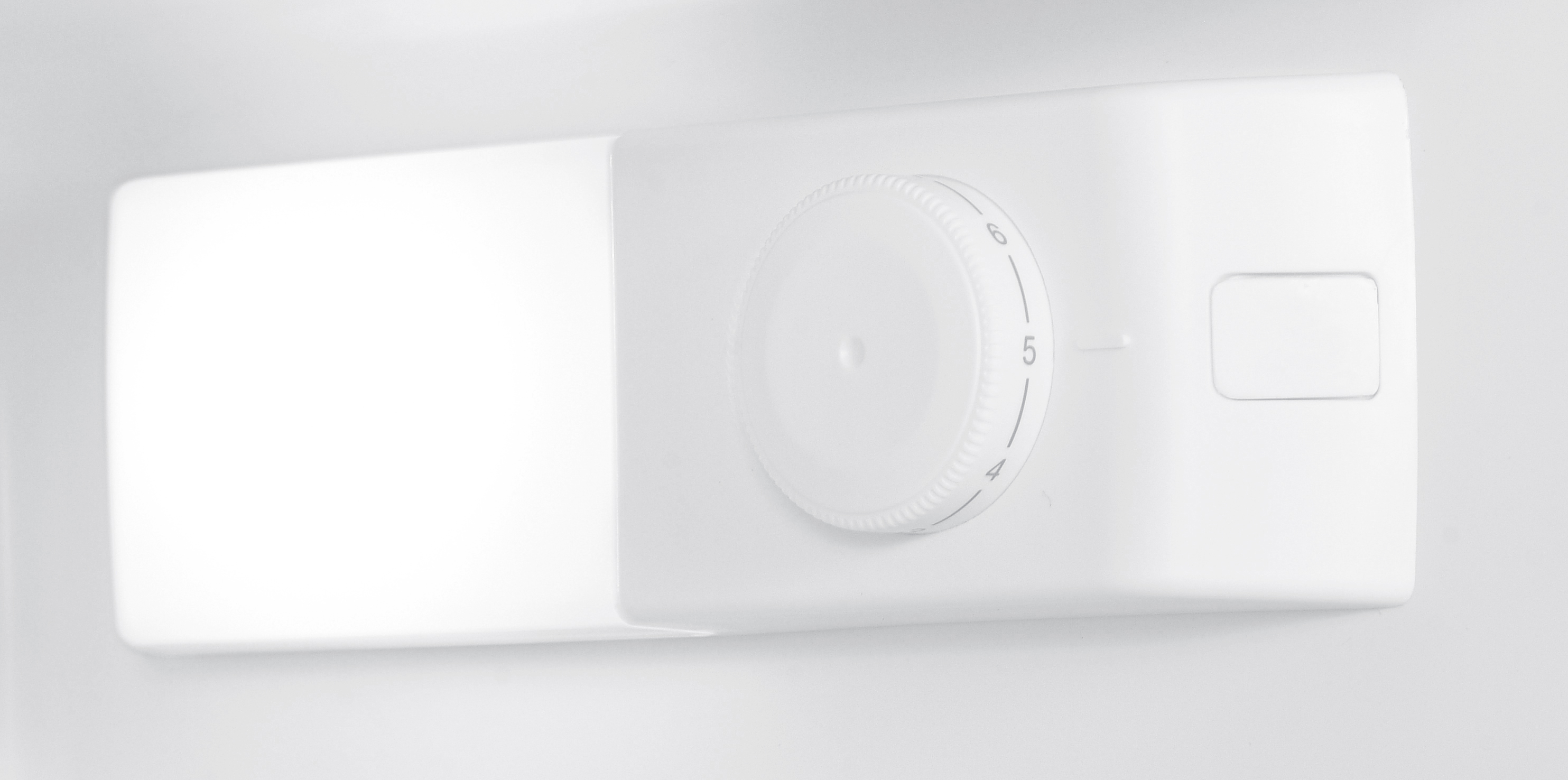 Gros plan sur un panneau de commande de réfrigérateur blanc. Il comporte un bouton rotatif avec des chiffres et un petit bouton rectangulaire.