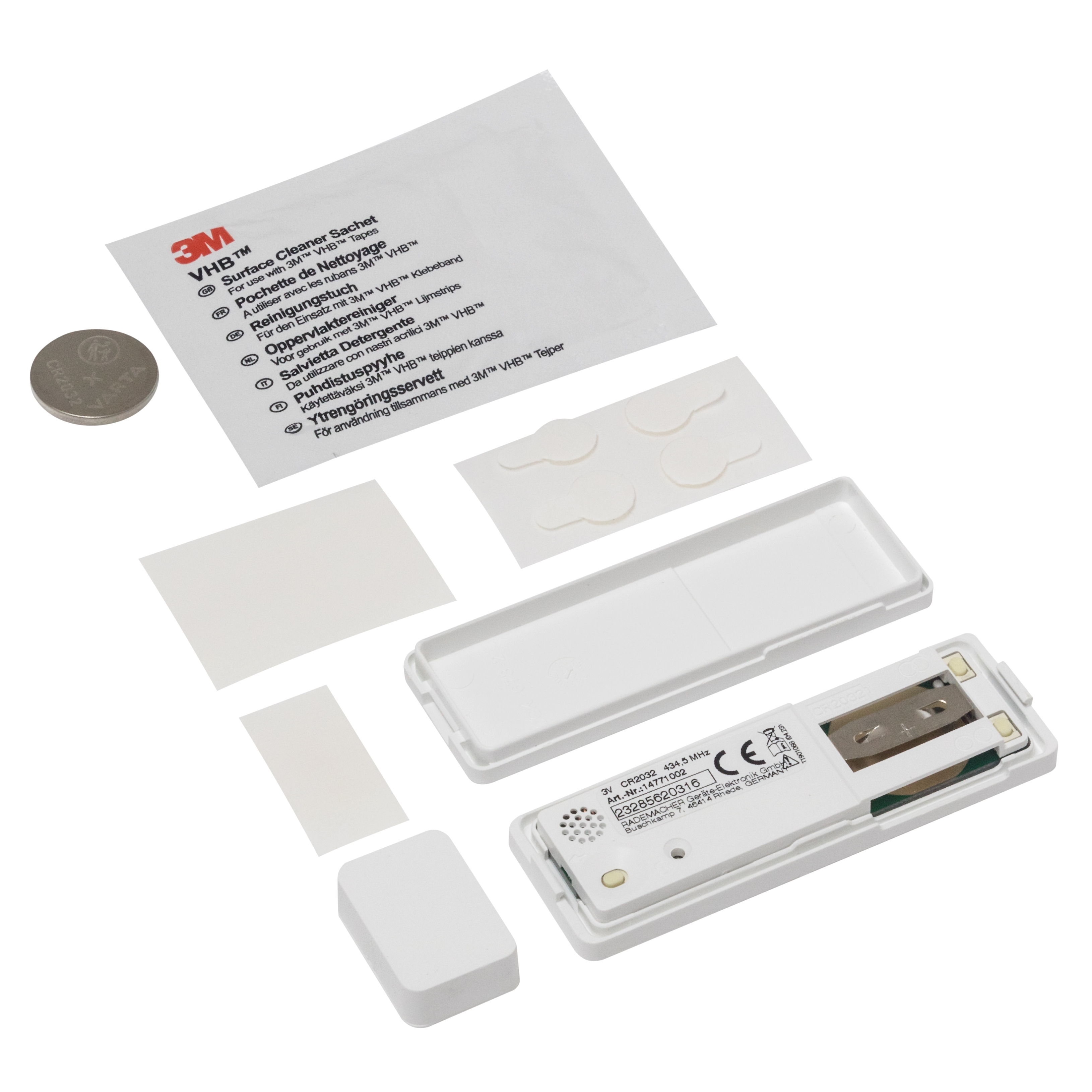 Weiße Geräteteile, eine Batterie und Reinigungspads auf weißer Oberfläche.