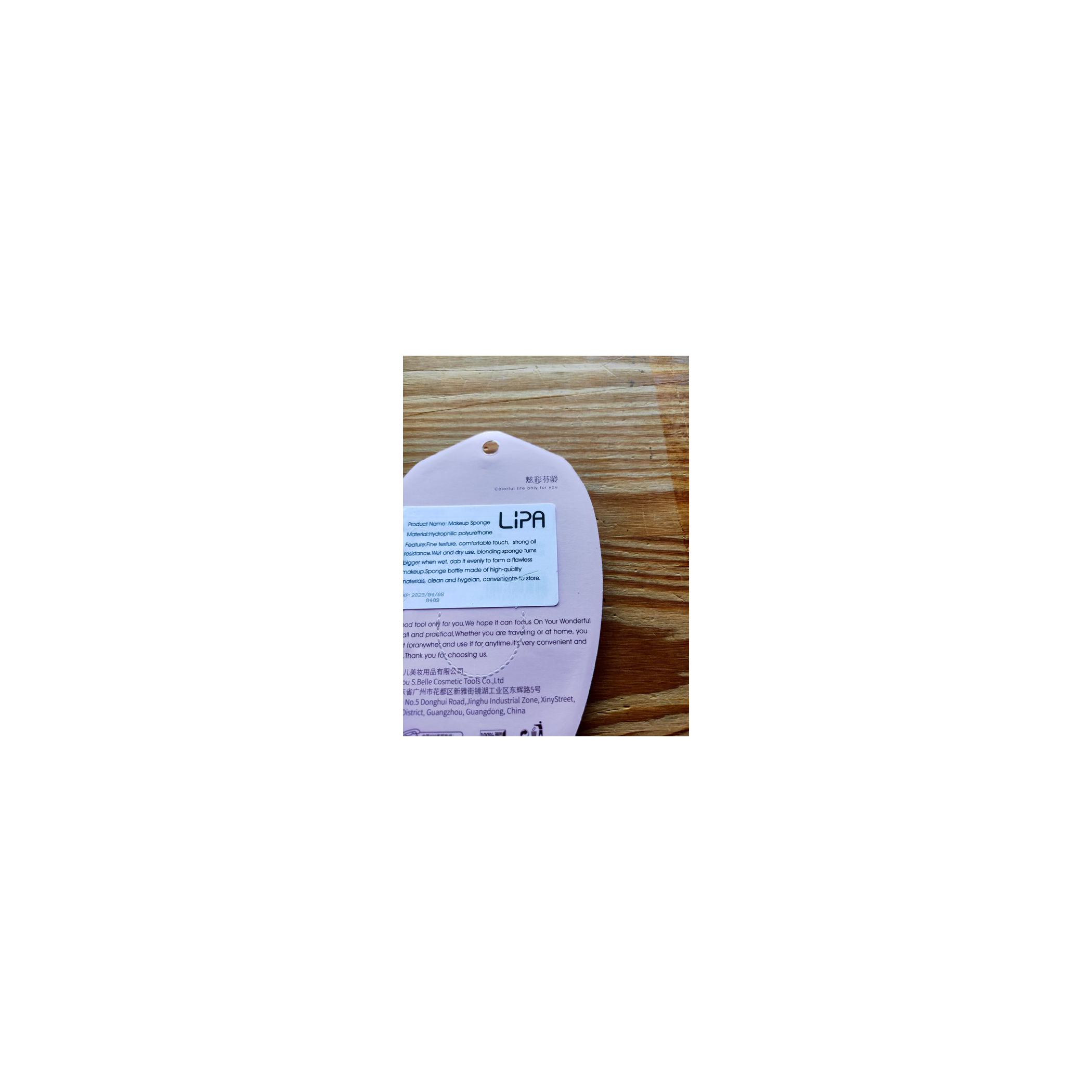 Weiß-violettes Produktpaket. Text in mehreren Sprachen. Ein kleines, abgerundetes, pinkes Element innen.