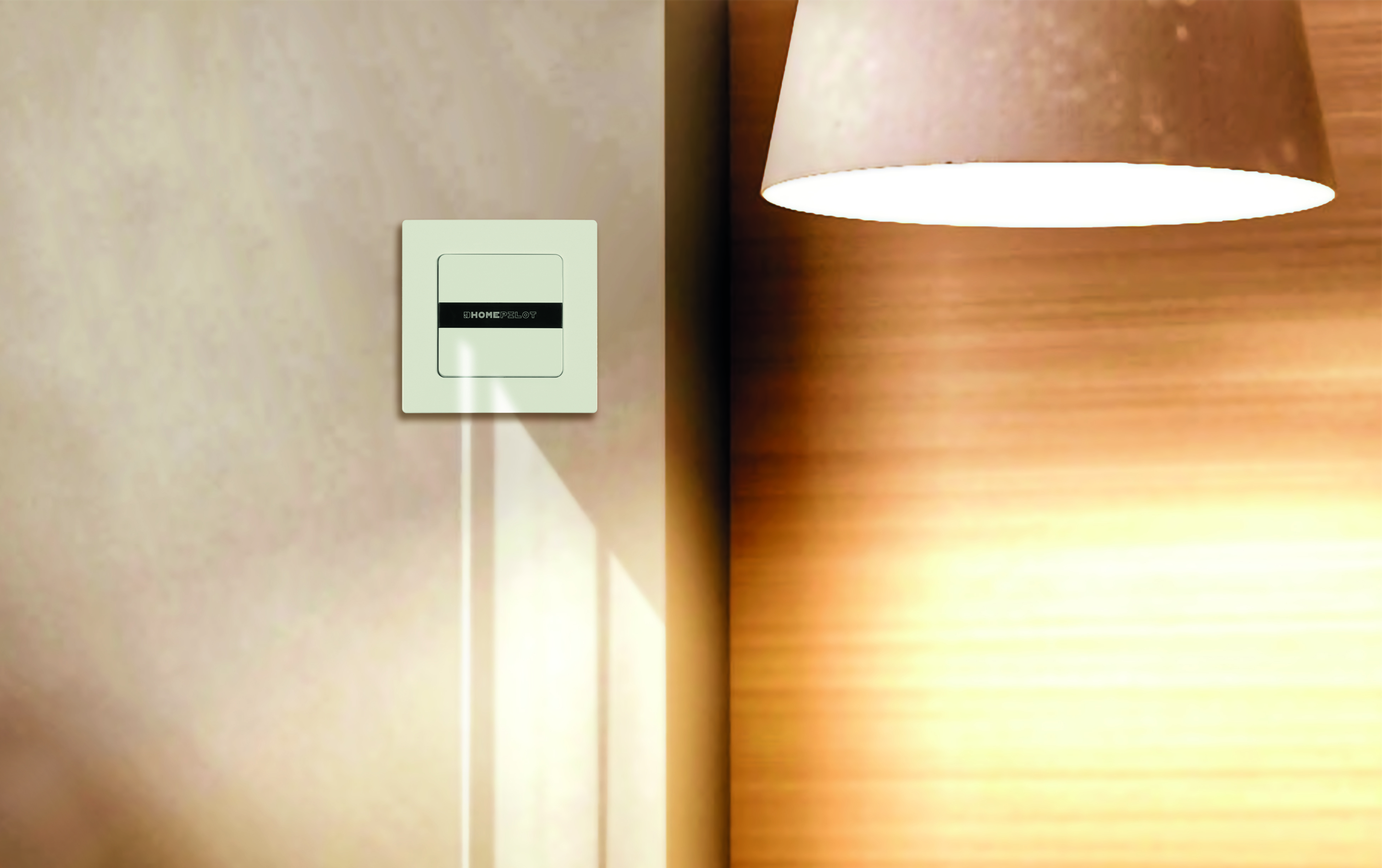 Weißer Lichtschalter an einer beigefarbenen Wand, neben einer Lampe.