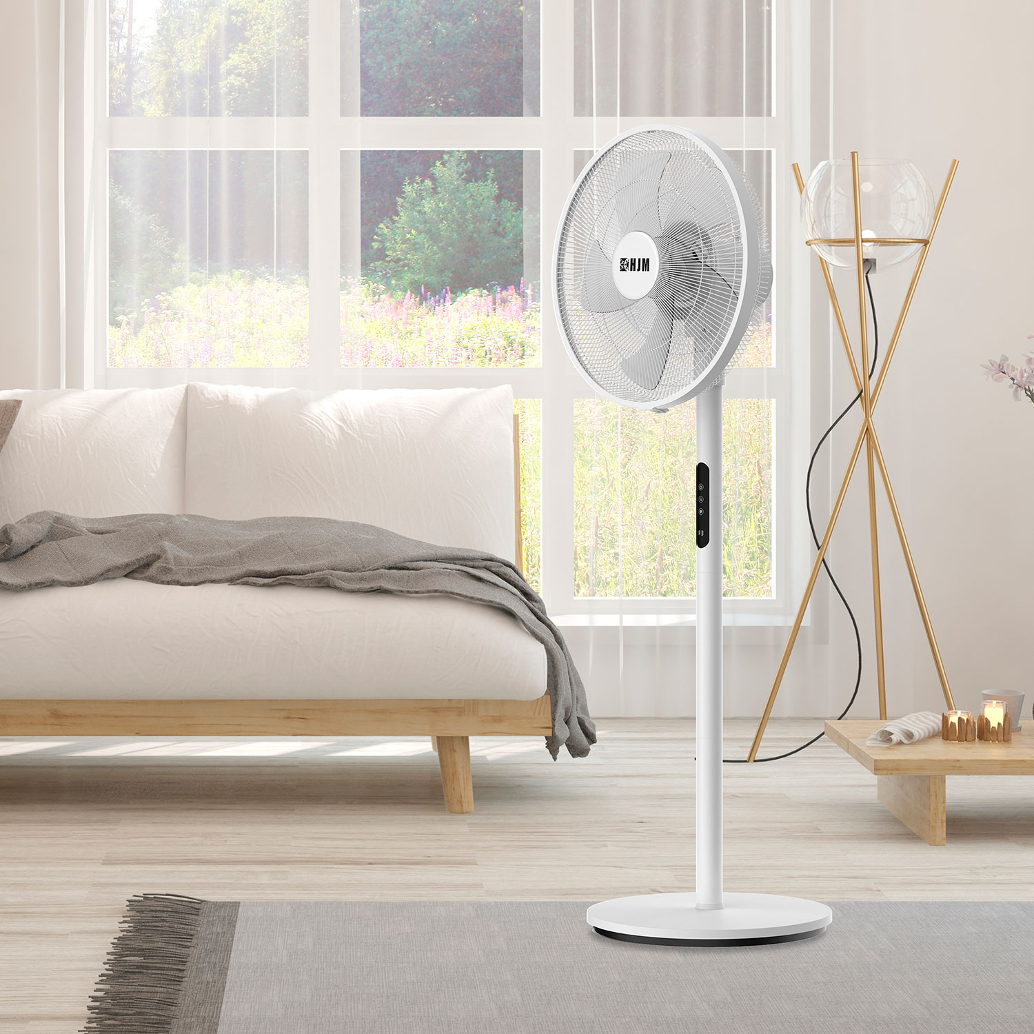 Ventilador de pie blanco en un salón. Un sofá y un elemento de madera al fondo.