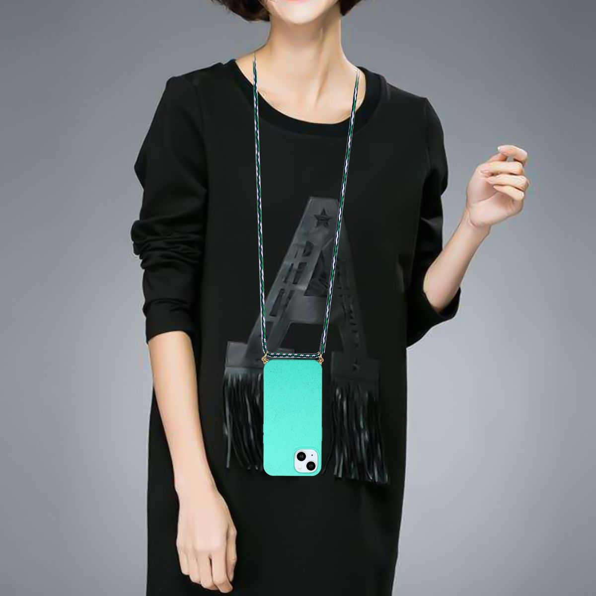 Eine Frau in einem schwarzen Kleid hält eine Handyhülle mit Trageriemen.