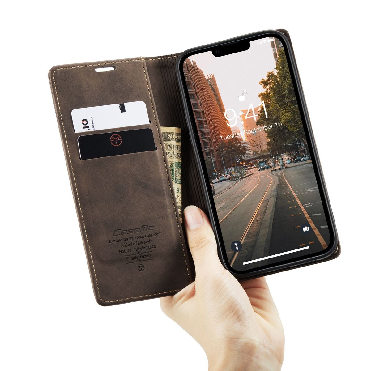 Hand, die eine braune Leder-Handyhülle mit Karten und Geld hält. Ein Telefon zeigt eine Stadtszene.
