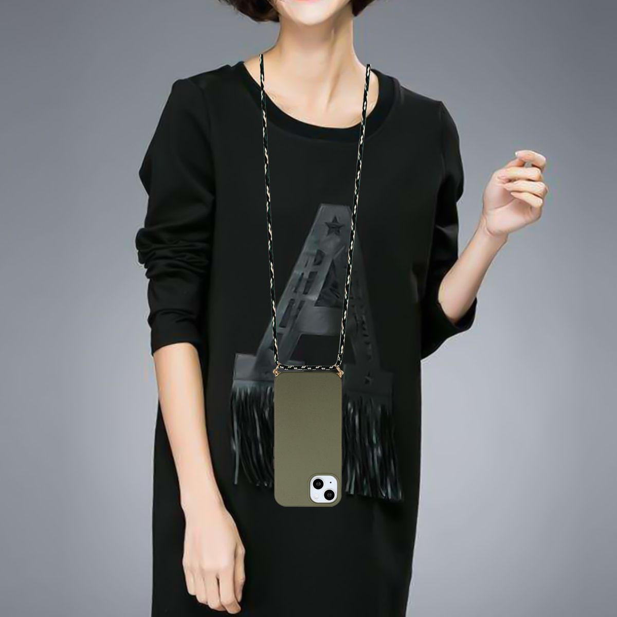 Eine Frau trägt ein schwarzes Kleid mit einem Telefon an einer Halskette, mit grüner Hülle.