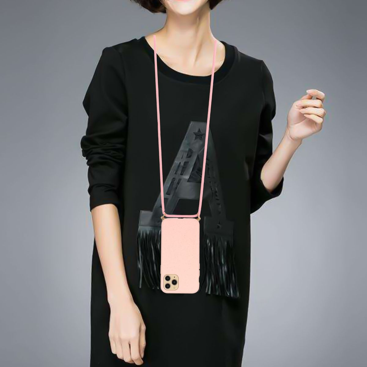 Frau trägt ein schwarzes Kleid mit einem Telefon in einer rosa Hülle, das um ihren Hals hängt.