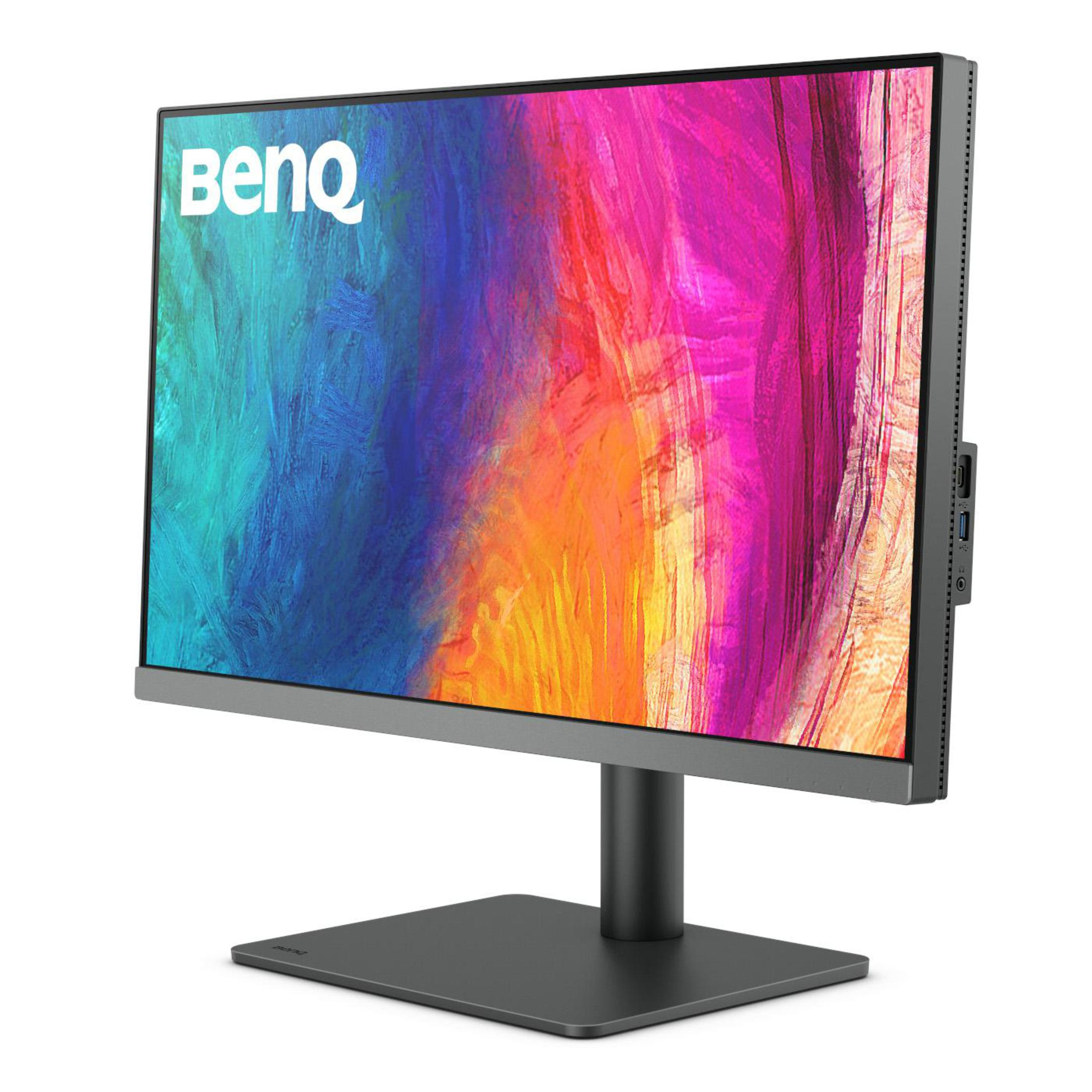Monitor BenQ z kolorowym tłem i czarną podstawą na białej powierzchni.