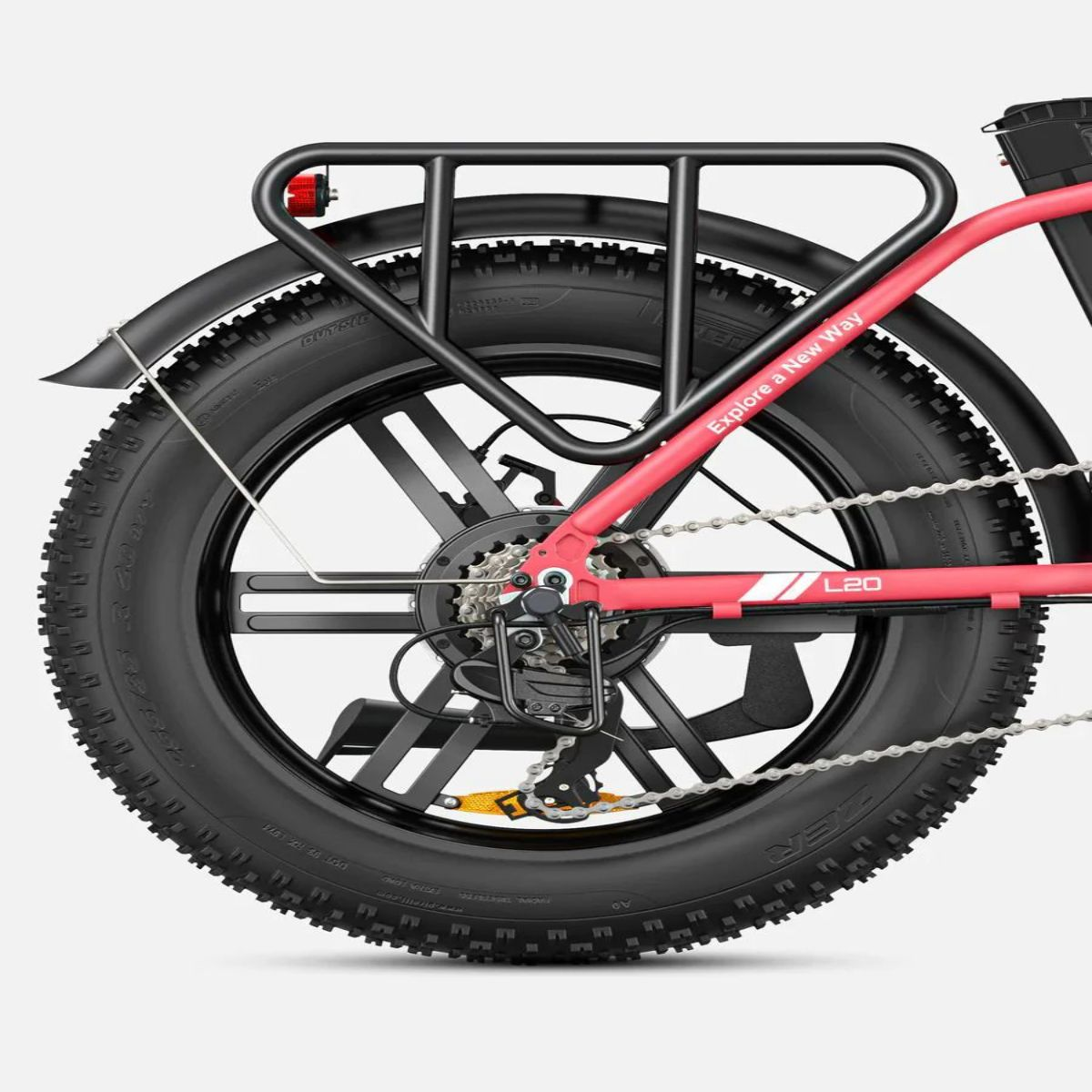 Ruota posteriore di una e-bike rossa con portapacchi nero. Il pneumatico riporta la scritta 'Explore a New Way'.