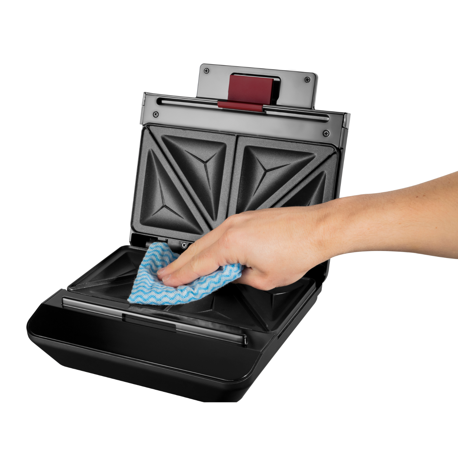 A hand cleaning a black sandwich maker with a blue and white cloth. 