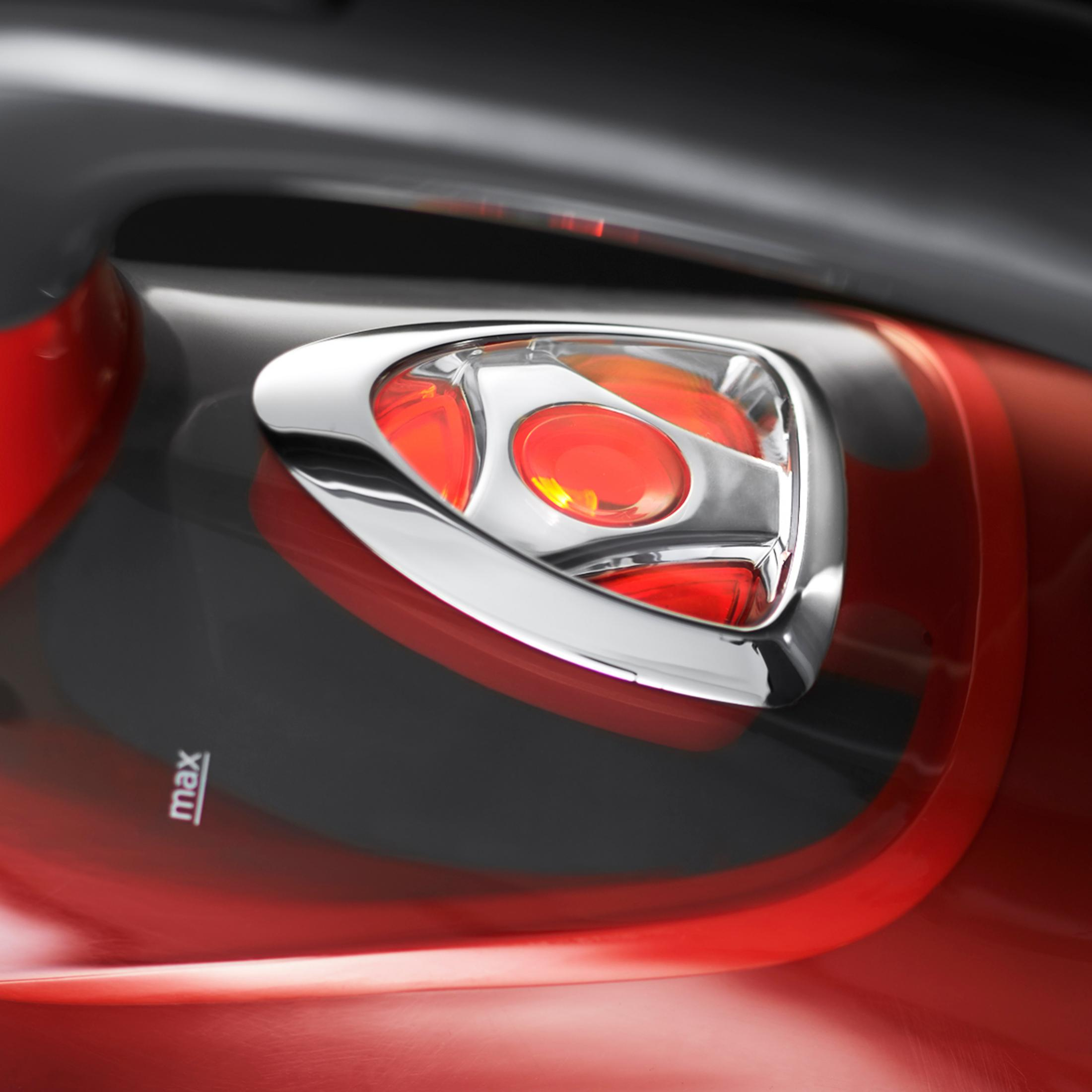 Zbliżenie czerwono-czarnego urządzenia z chromowanym akcentem i przezroczystym czerwonym detalem.