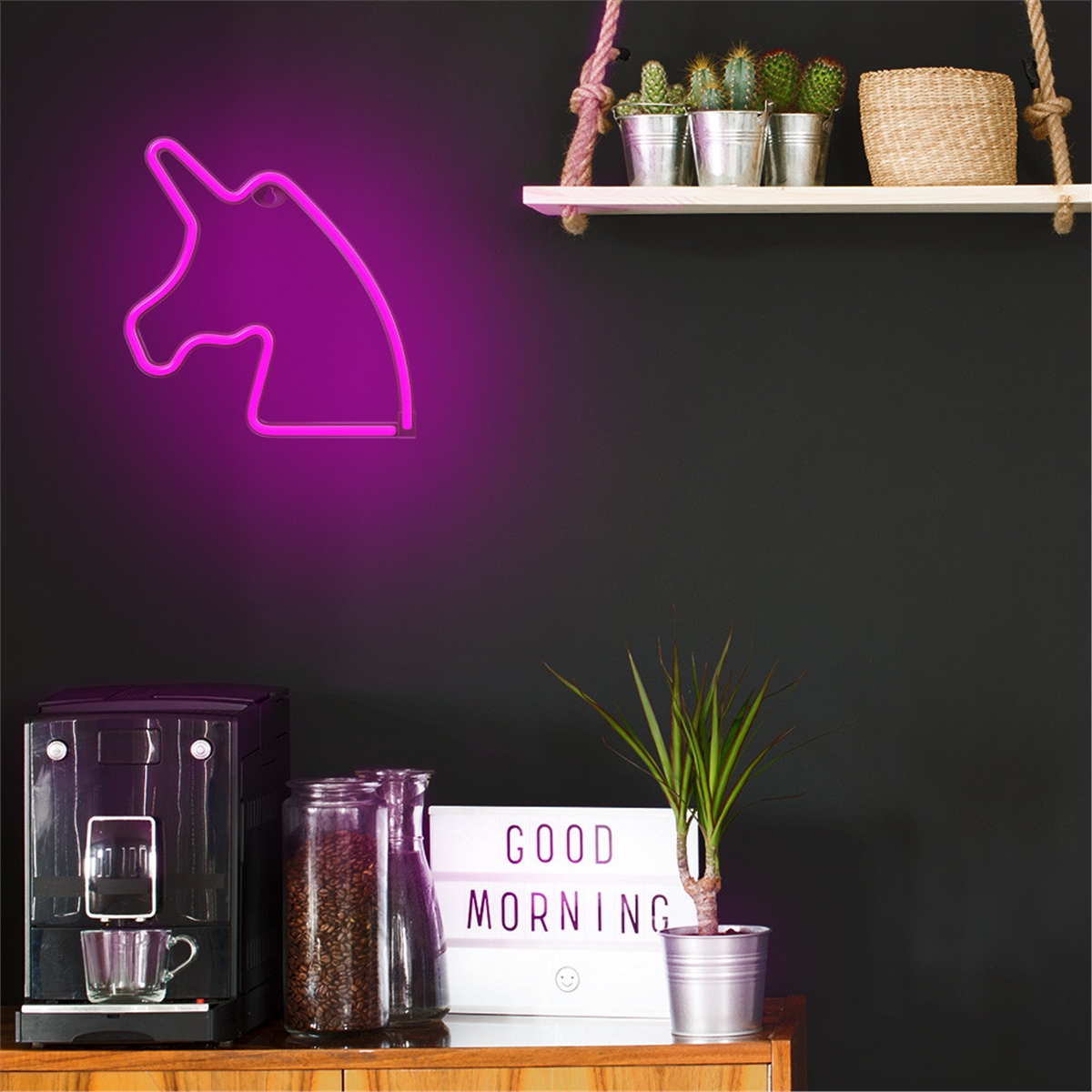 Ein Neon-Einhornkopf, eine Kaffeemaschine und eine Pflanze. Ein Schild sagt 'Good Morning'.