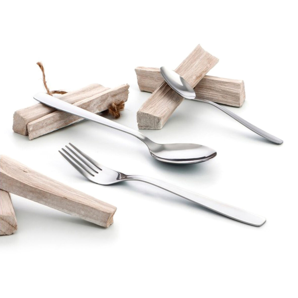 Set di posate: forchetta, cucchiai e blocchi di legno disposti su superficie bianca.