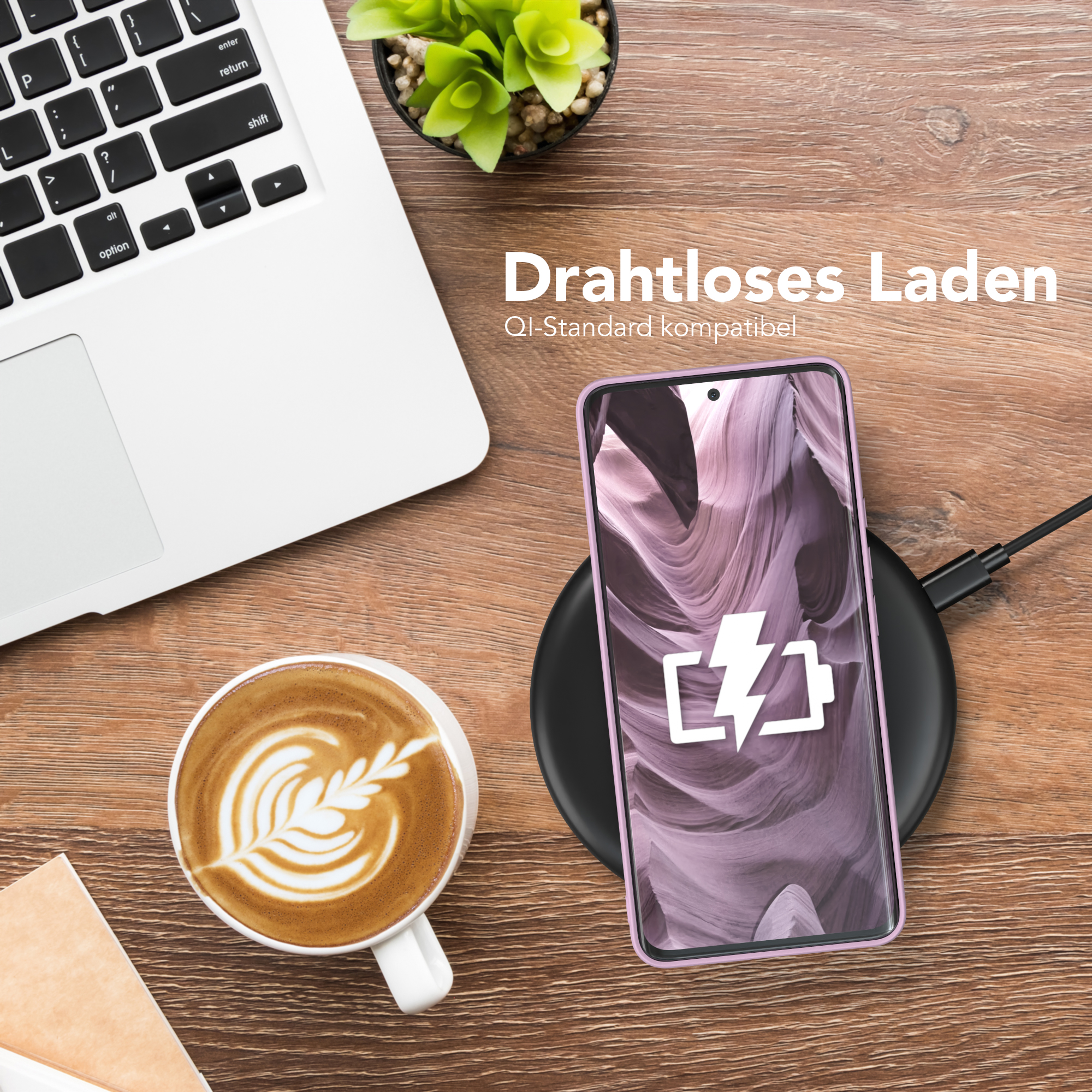 Telefon wird auf einem kabellosen Ladegerät aufgeladen. Im Hintergrund befinden sich eine Kaffeetasse und ein Laptop.