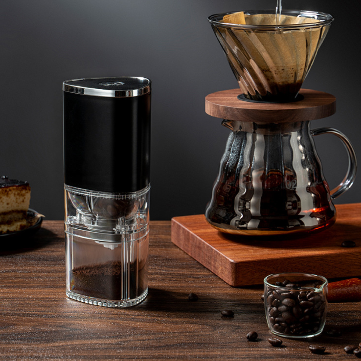 Kaffeemaschine mit Bohnen, Karaffe und Kuchenstück.