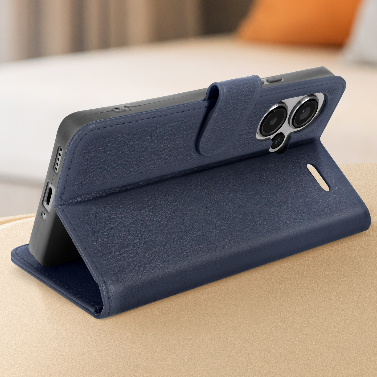 Custodia per telefono in pelle blu navy, aperta per rivelare il telefono. Superficie marrone chiaro.