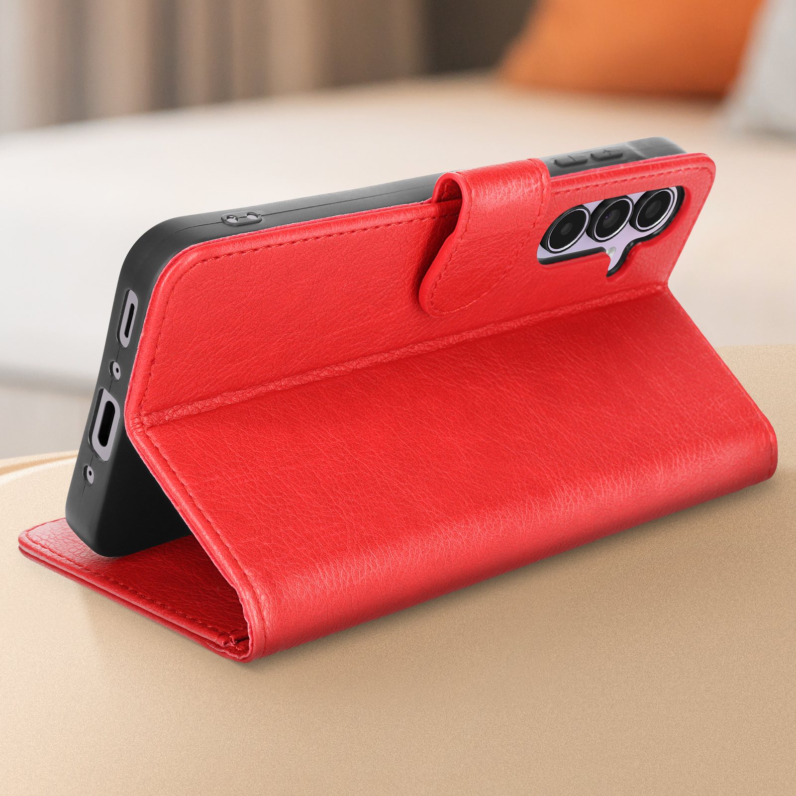 Custodia per telefono rossa aperta su un tavolo. Il telefono è visibile. La custodia è simile alla pelle.