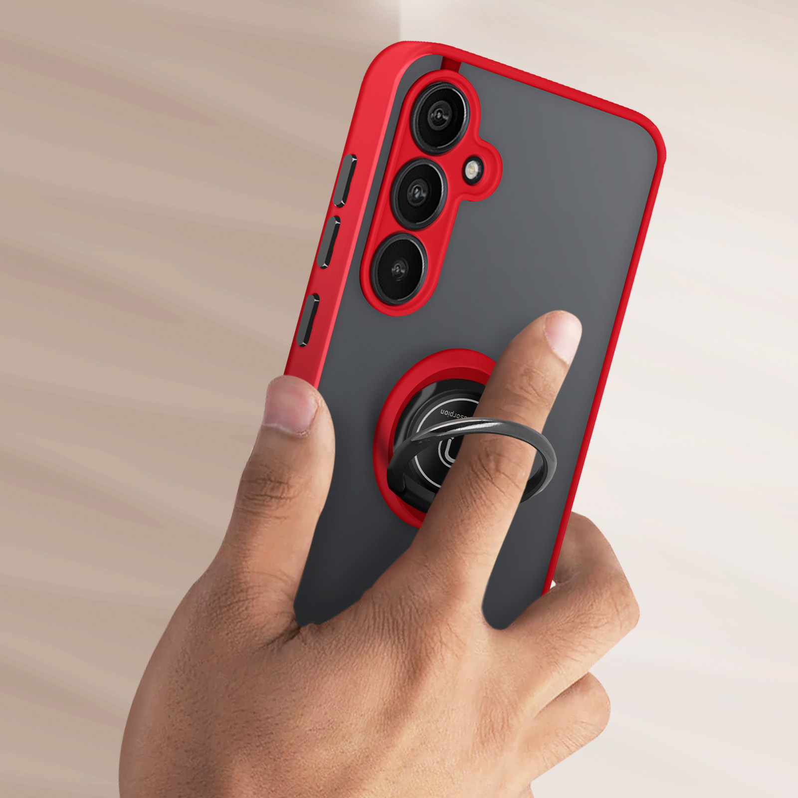 Telefono grigio con cornice rossa e supporto ad anello, tenuto da una mano.