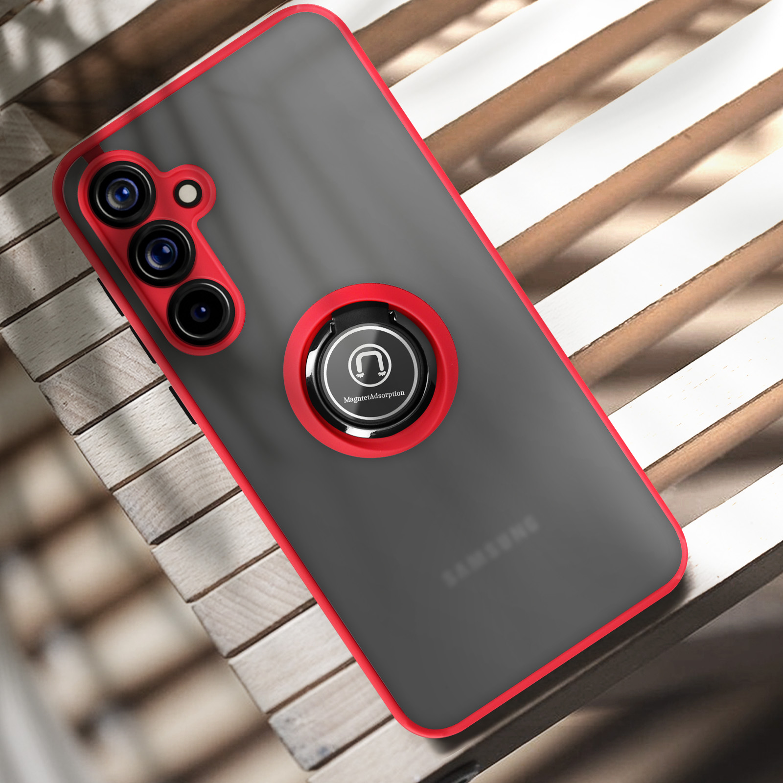 Una custodia grigia per telefono con cornice rossa, che tiene un telefono con tre fotocamere e un portaanelli.