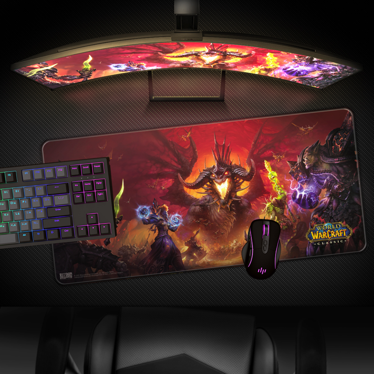 Gaming-Setup mit Tastatur, Maus, Mauspad mit Warcraft-Kunst und gebogenem Monitor auf dunkler Oberfläche.
