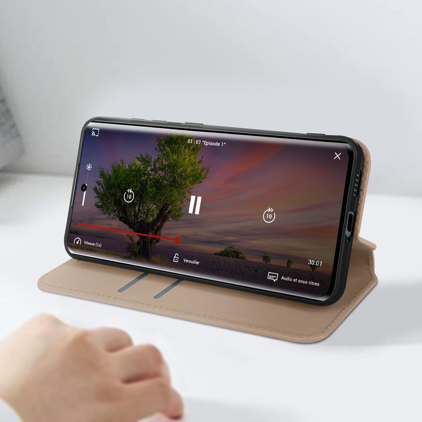 Telefon in einer Hülle, spielt Video. Beige Hülle, zeigt einen Baum und Himmel.
