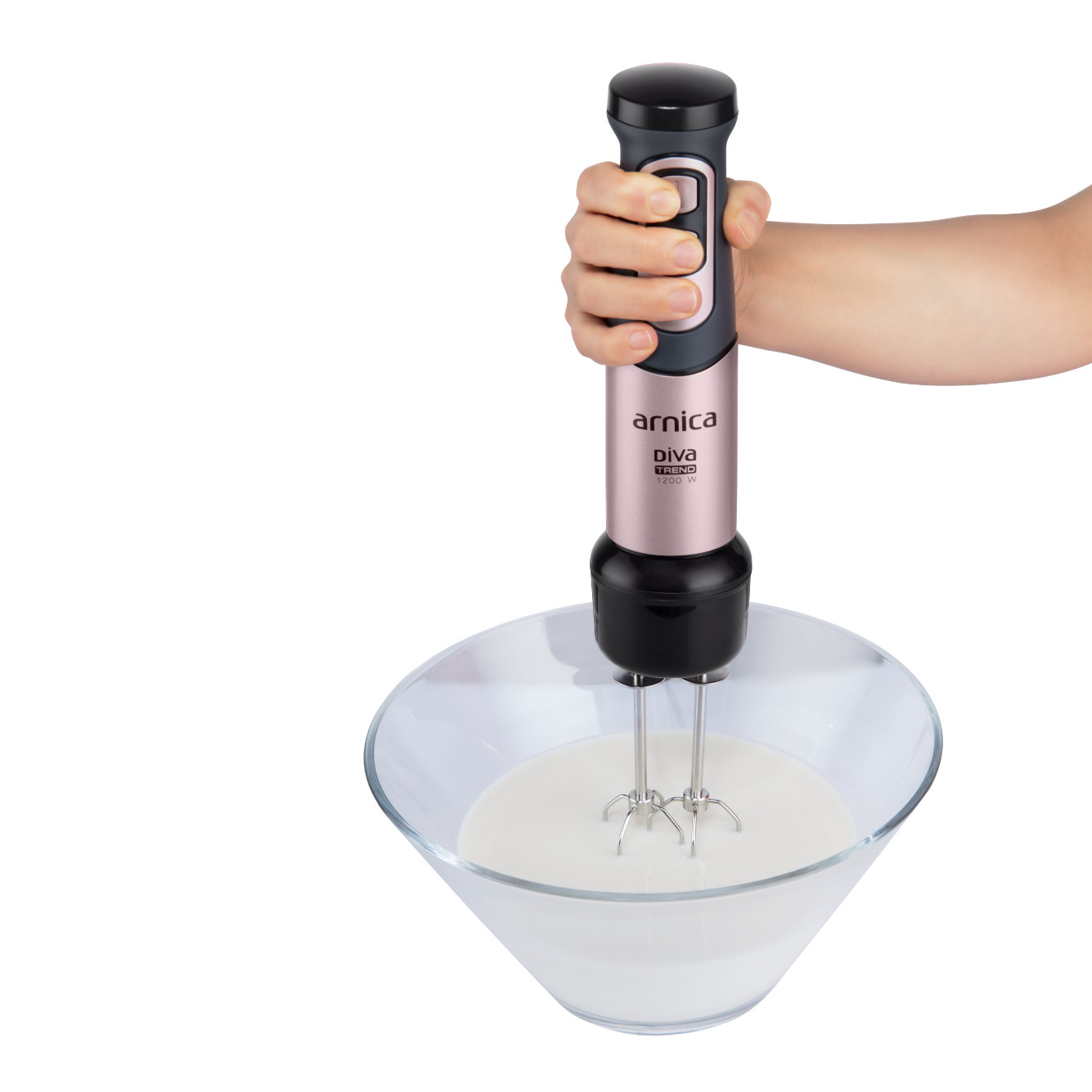 Hand hält rosa-schwarzen Stabmixer über Glasschüssel mit Schlagsahne.