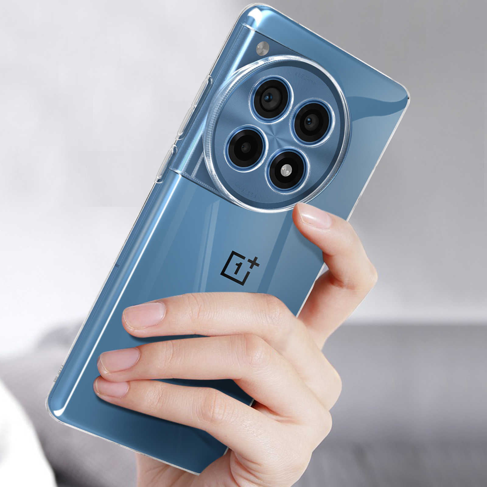 Custodia per telefono trasparente blu. Mano che tiene il telefono. Il telefono ha tre fotocamere.