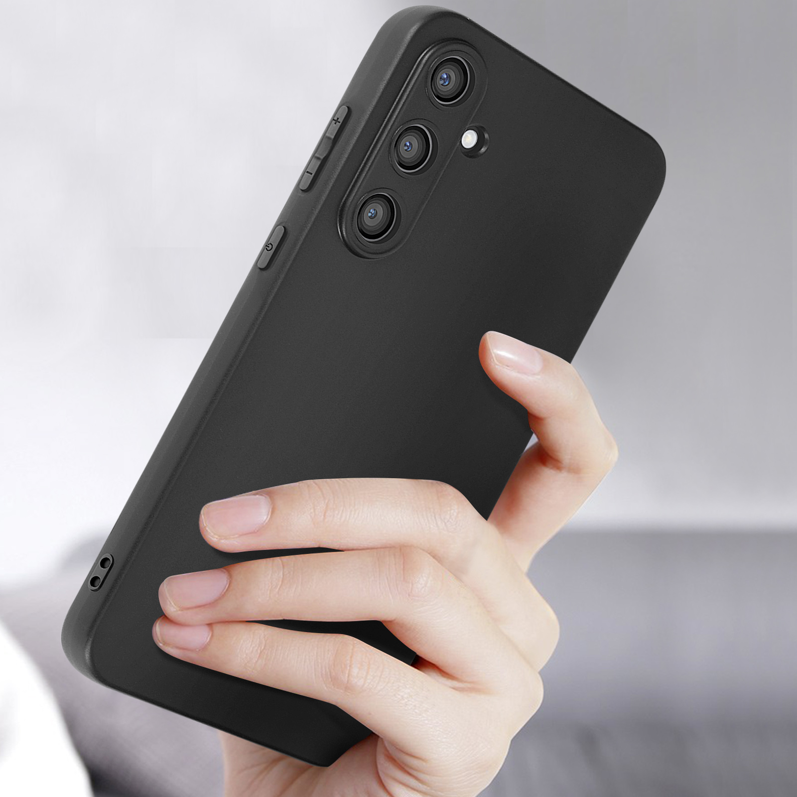 Mano che tiene una custodia nera. Tre obiettivi della fotocamera visibili.