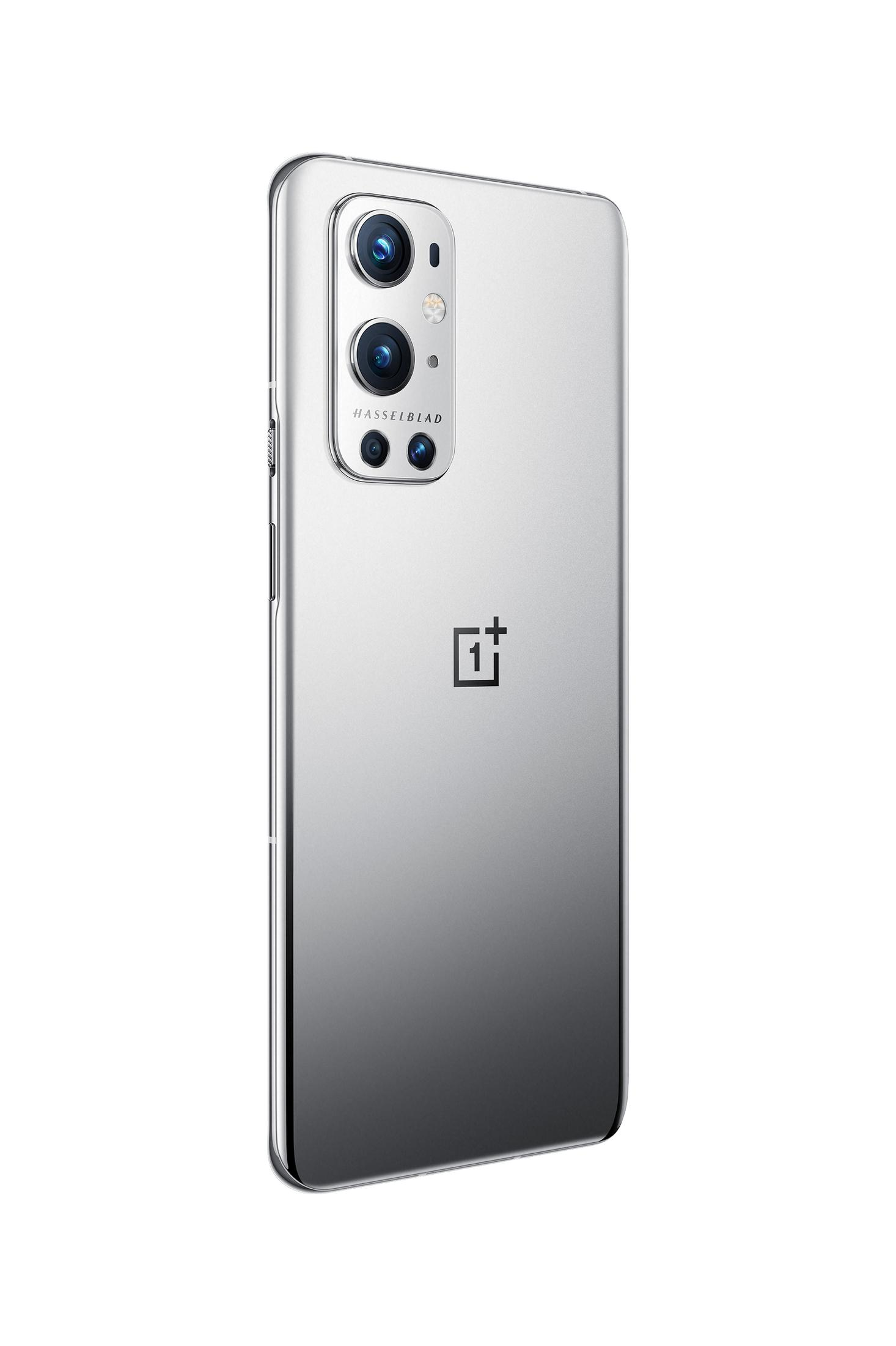 Teléfono plateado con triple cámara. Logotipo de OnePlus abajo. Fondo blanco.