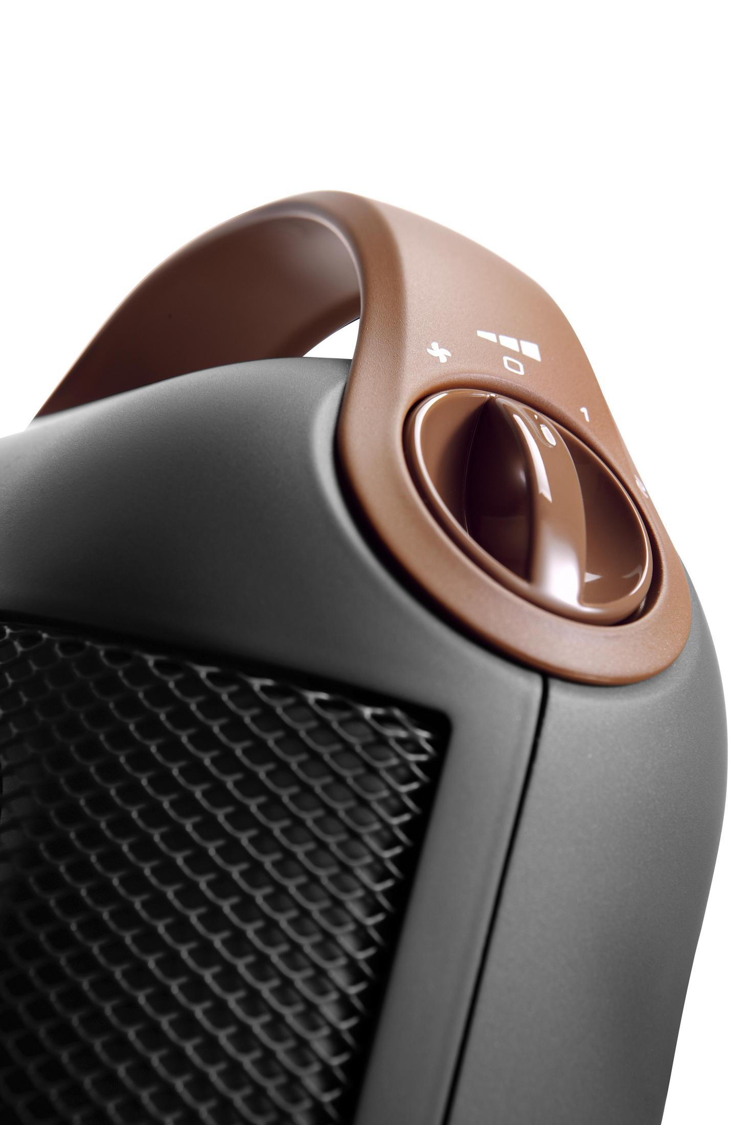 Szczegół czarnego i brązowego grzejnika z brązowym uchwytem i pokrętłem.