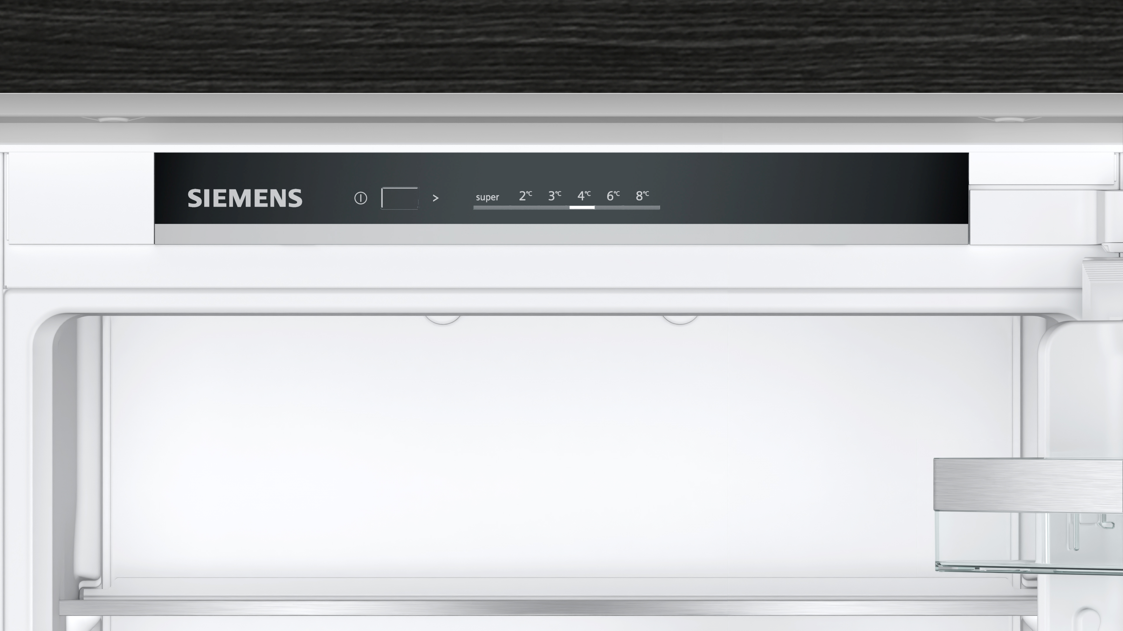 El interior de un refrigerador con un panel de control en la parte superior y estantes vacíos. El logotipo de Siemens es visible.