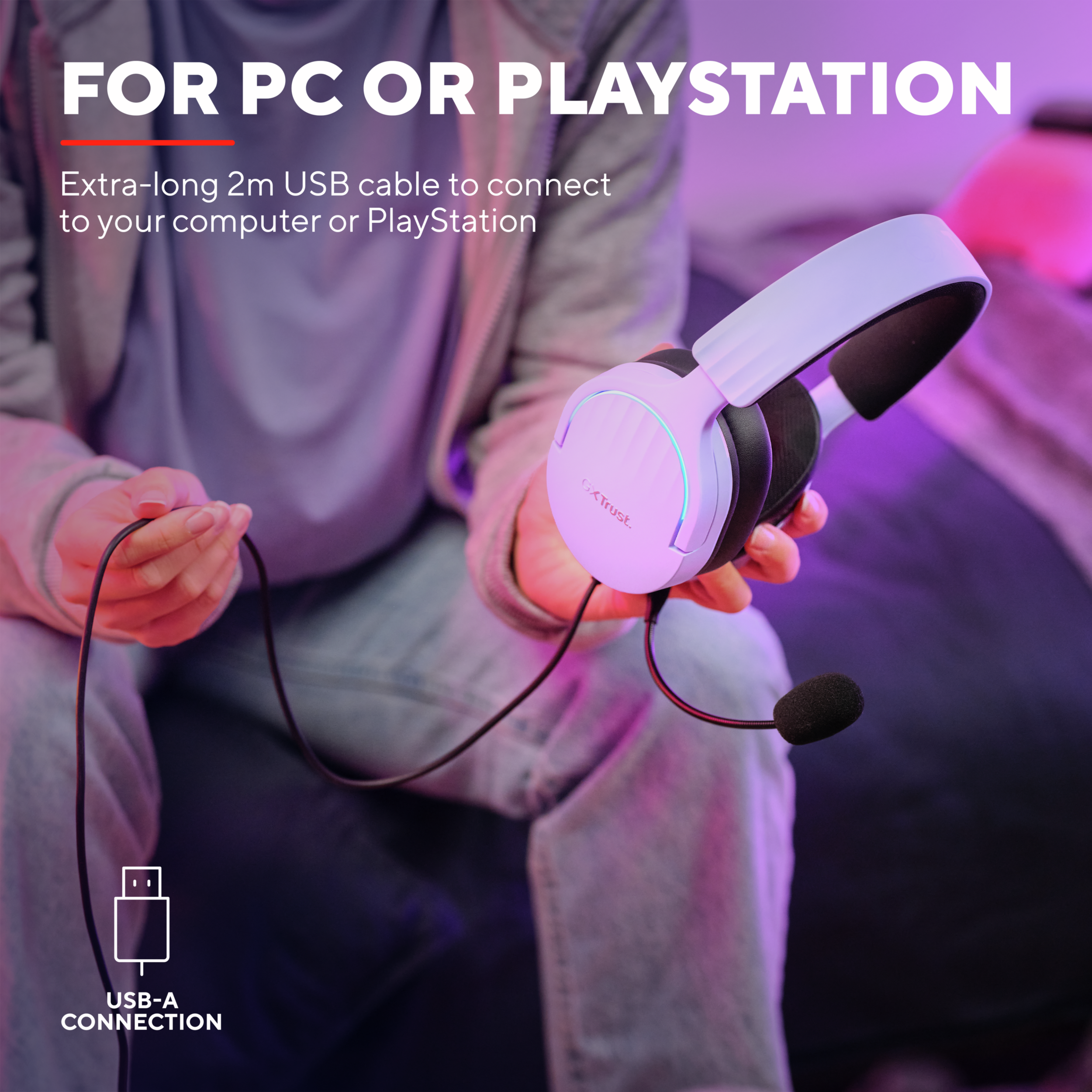 Osoba trzyma biały zestaw słuchawkowy z mikrofonem, podłączony do kabla USB.