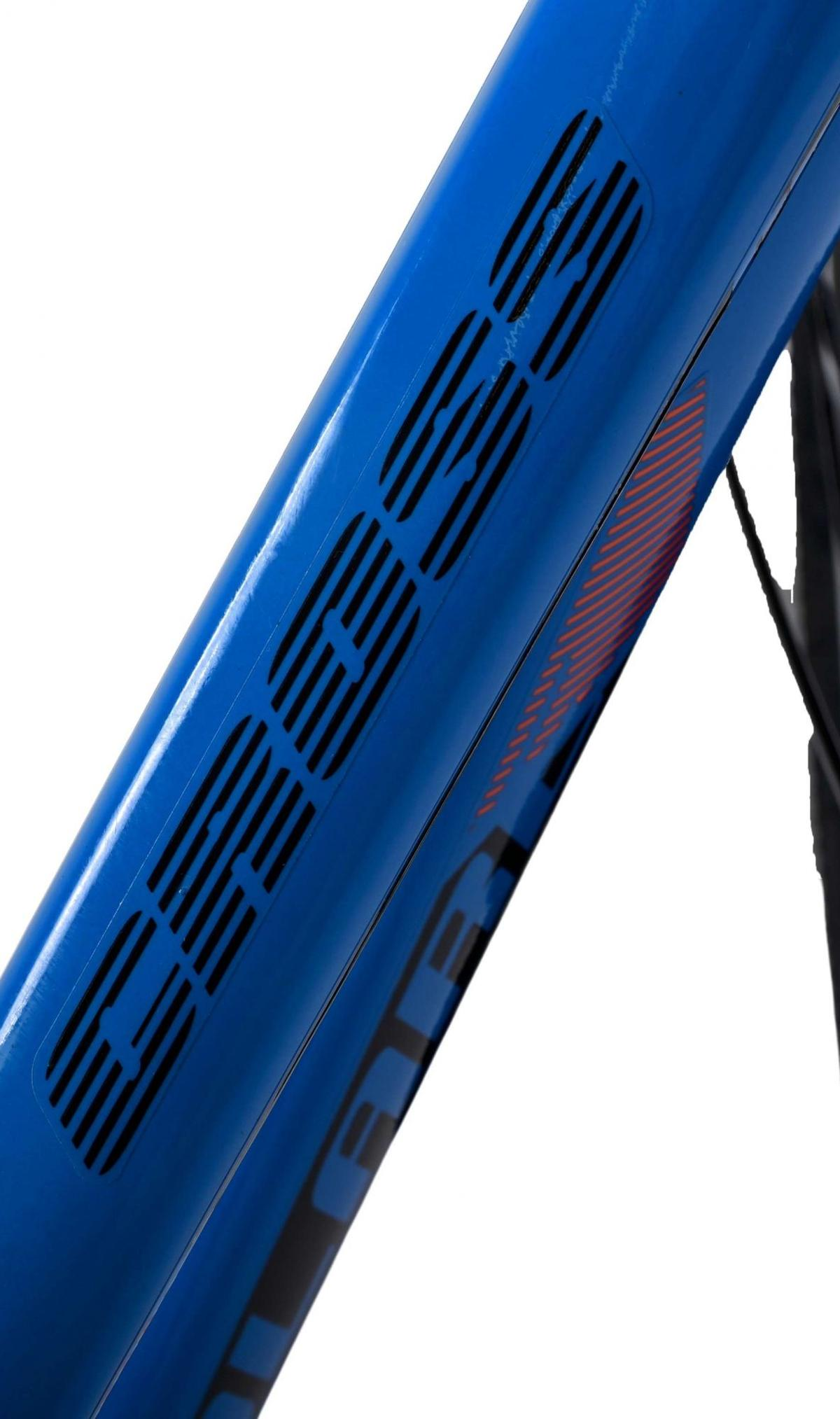 Nahaufnahme eines blauen Fahrradrahmens mit dem Wort 'CUBE' in schwarzen Streifen und roten Akzenten.