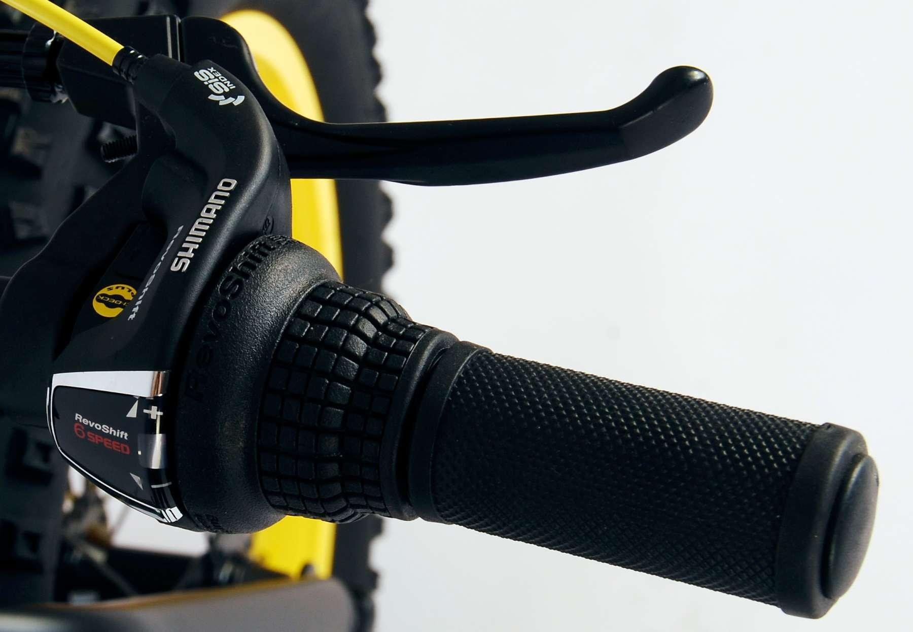 Fahrradlenkergriff mit Shimano-Bedienelementen und schwarzem Griff. Gelbe Akzente.