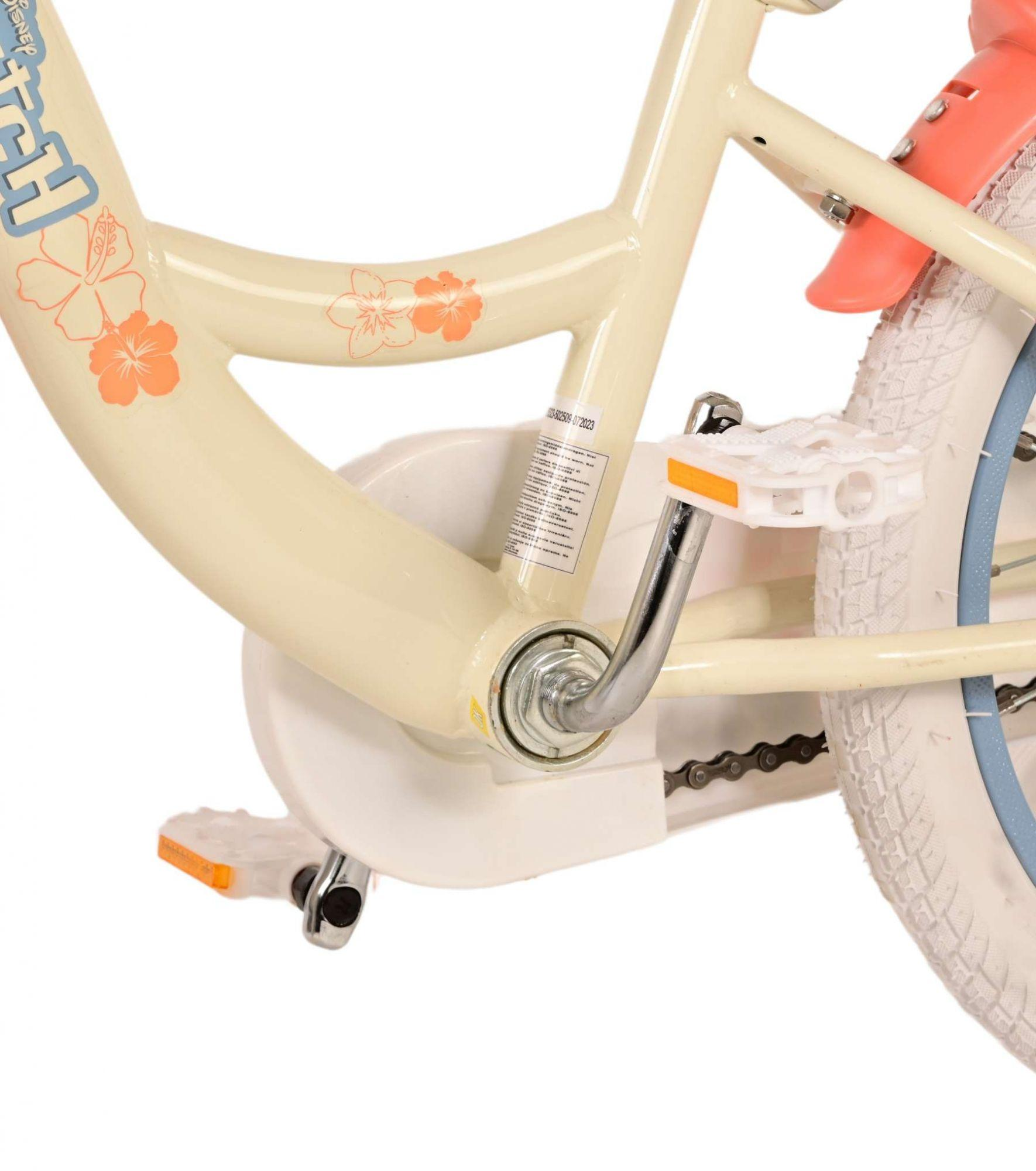 Nahaufnahme eines hellbeigen Kinderfahrradrahmens. Der Rahmen hat Blumenaufkleber und einen Kettenschutz.