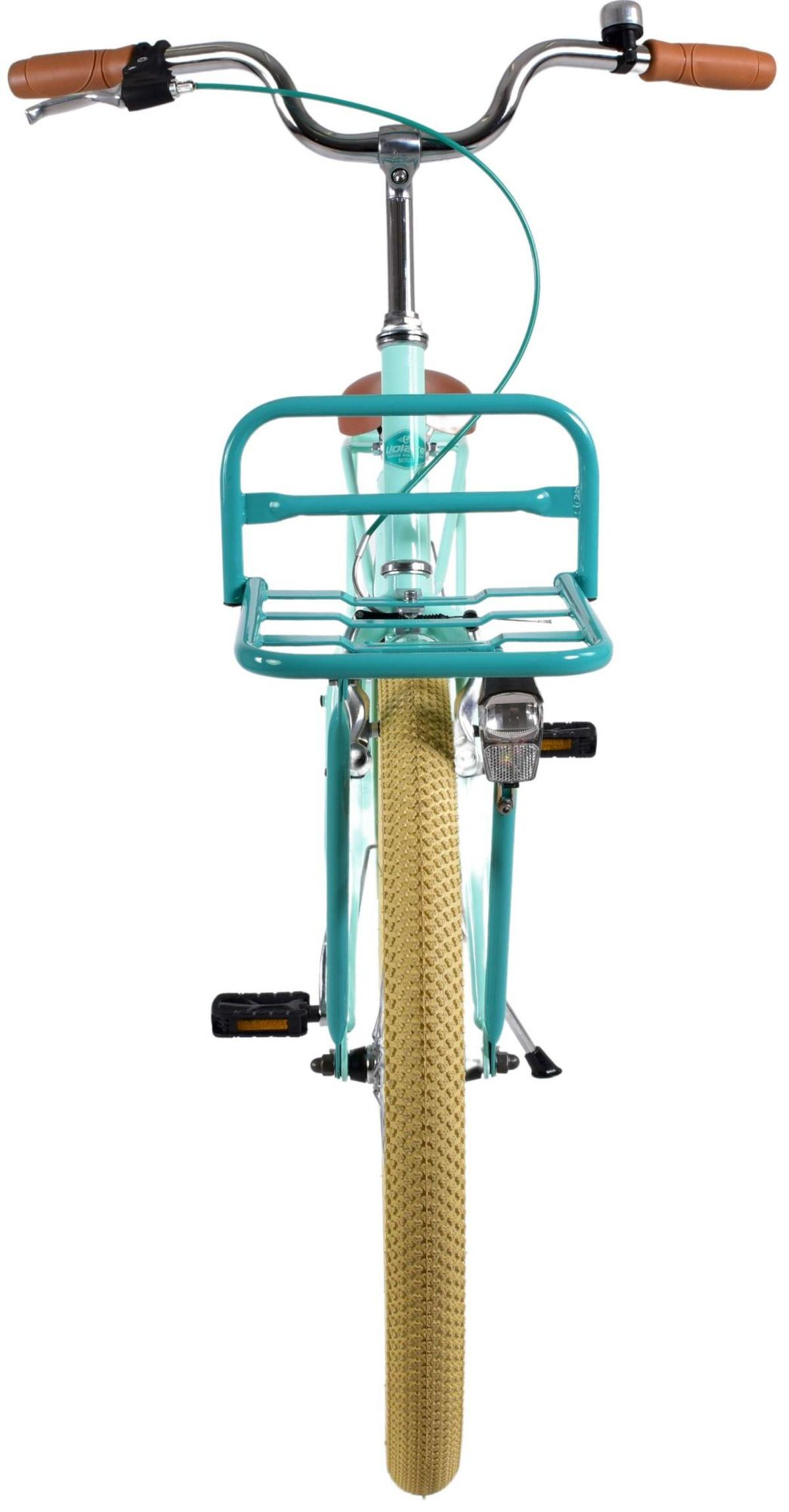 Ein türkisfarbenes Fahrrad mit Korb, hellbraunen Reifen und braunen Lenkern vor weißem Hintergrund.