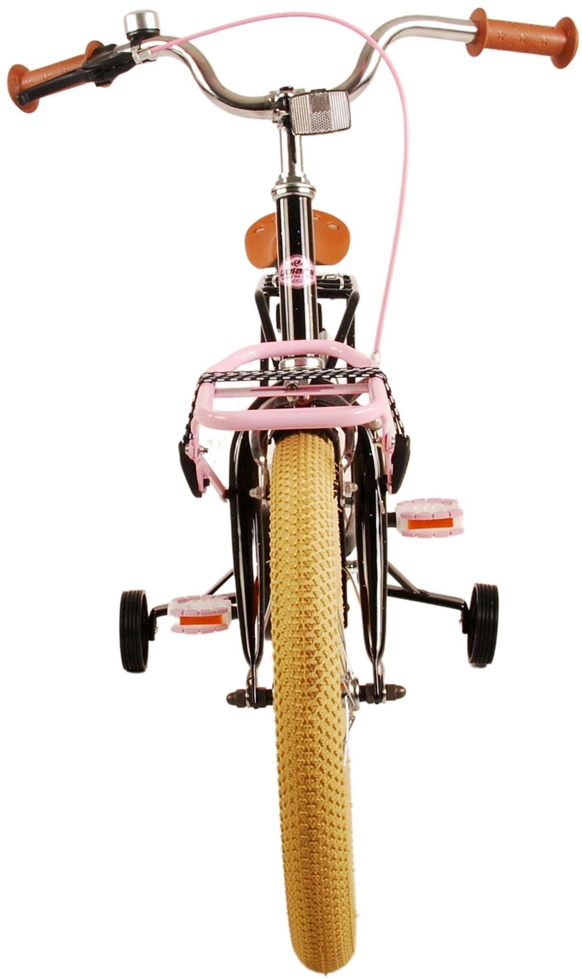 Das Kinderfahrrad ist rosa und schwarz. Es hat Stützräder und einen Lenkerkorb.