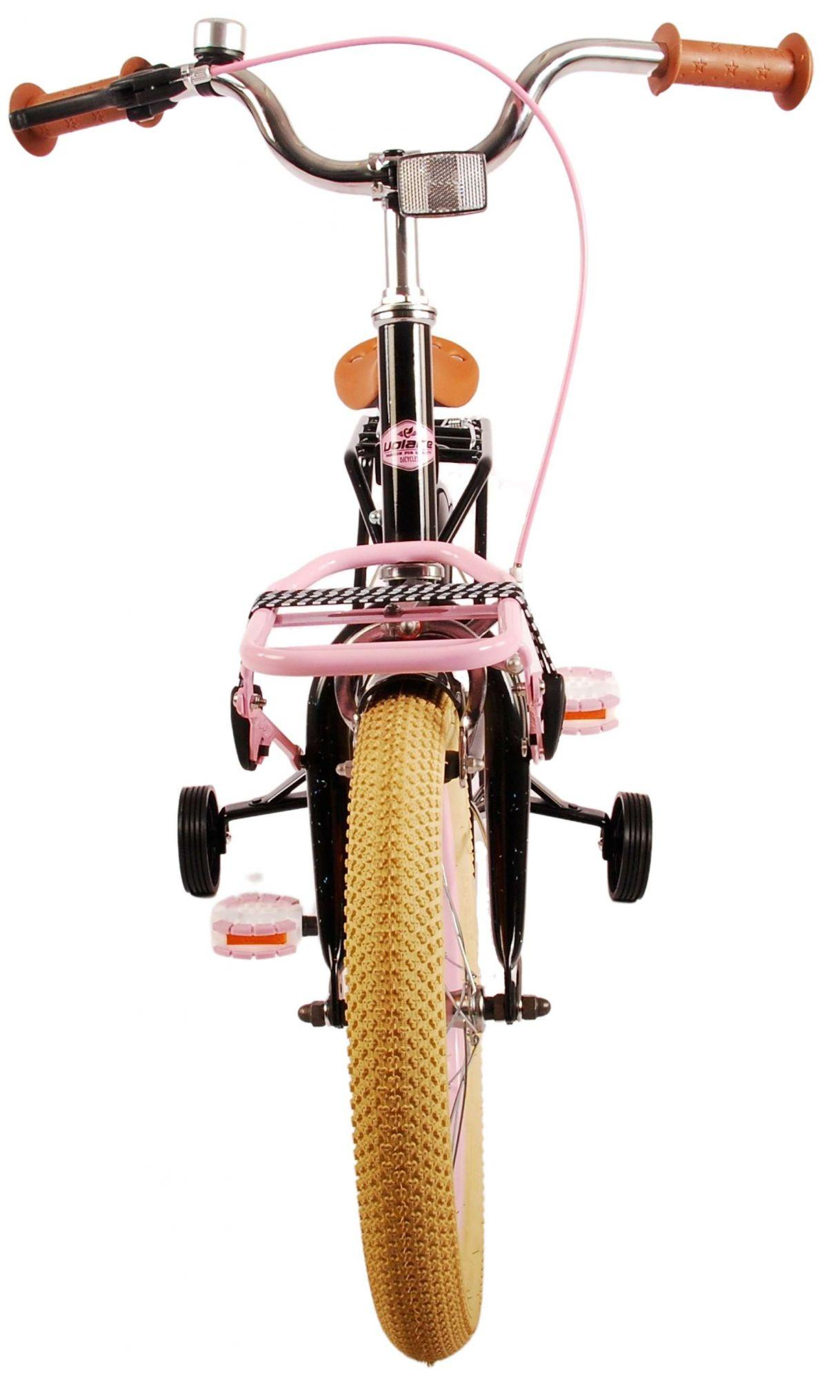 Vorderansicht eines rosa Fahrrads. Rosa Rahmen, Räder und Lenker. Stützräder und ein Korb.