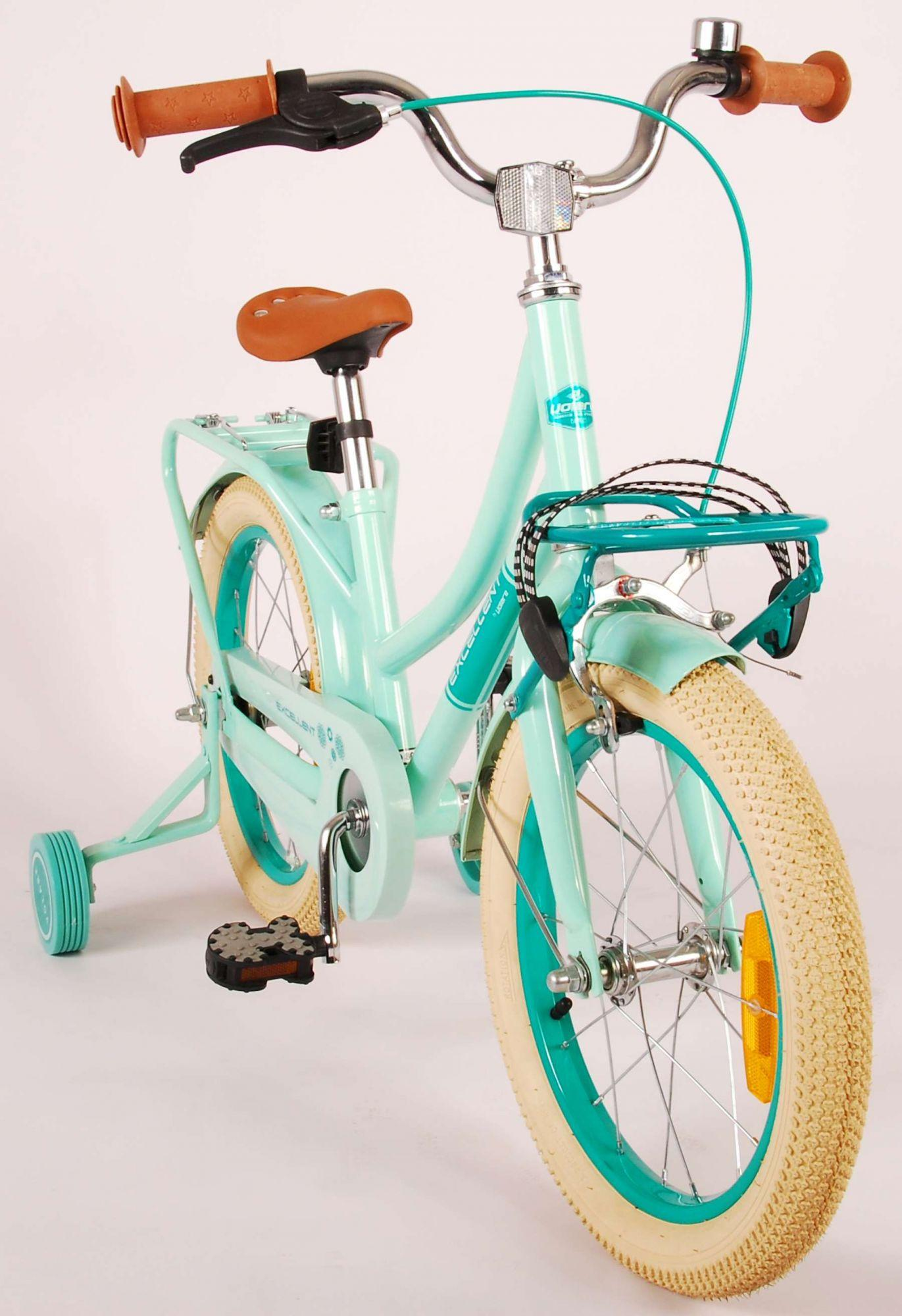 Ein hellblaues Fahrrad mit Stützrädern, braunem Sitz und Korb vorne. Es hat helle Reifen.