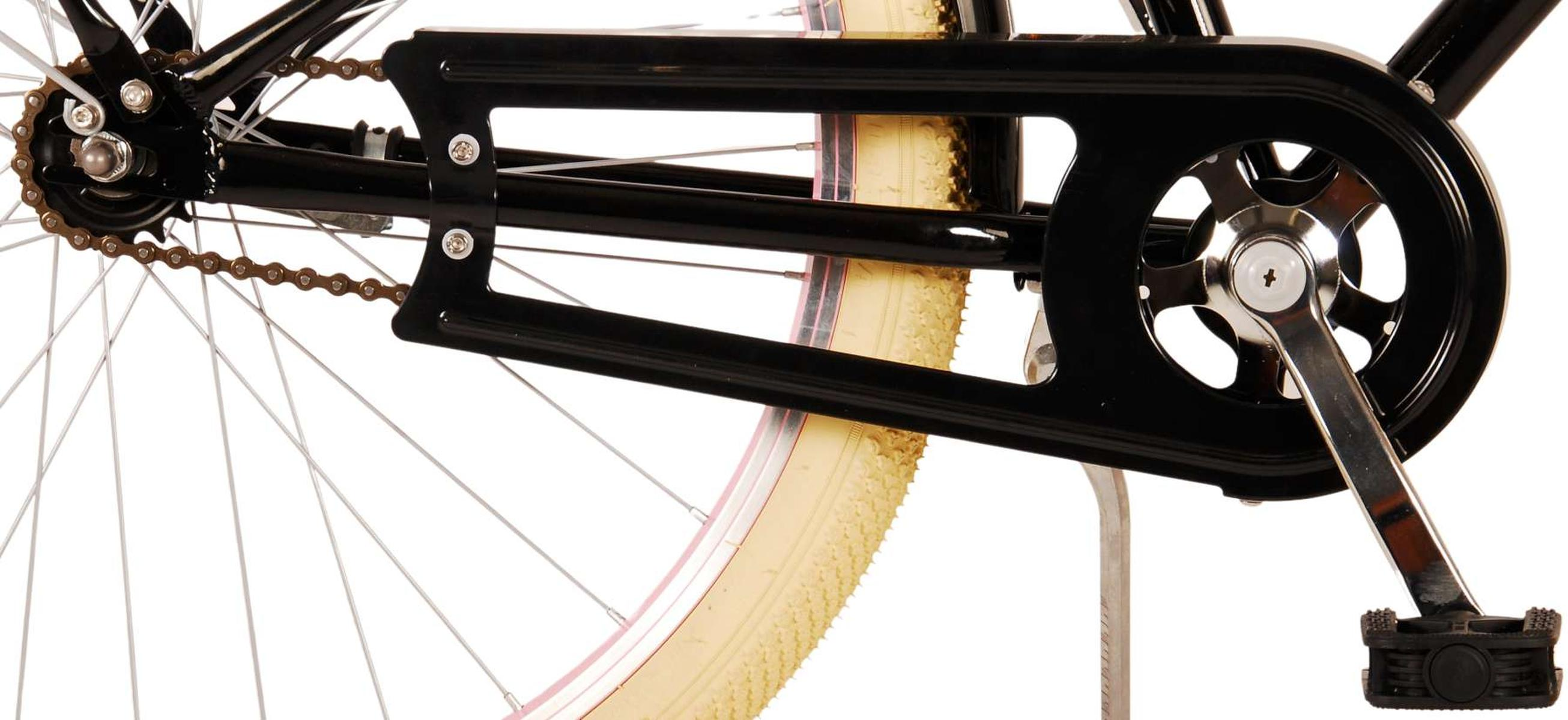 Schwarzes Fahrrad Detail: Rad mit beigem Reifen, Kette, Kettenschutz und Pedalen. Weißer Hintergrund.