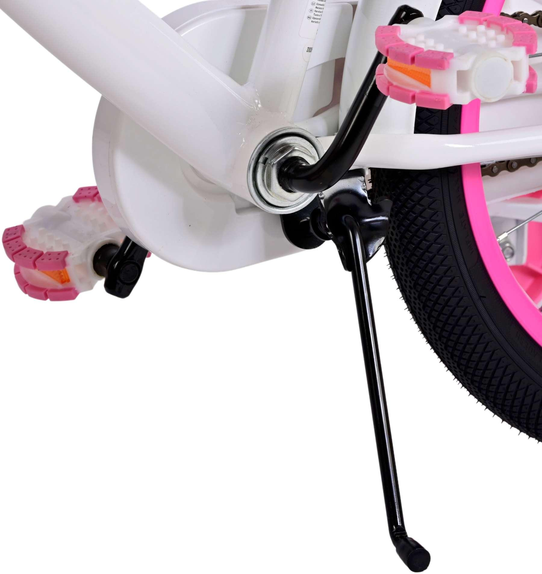 Nahaufnahme der Komponenten eines weißen Fahrrads: Pedale, Ständer und Hinterrad mit rosa Akzenten.