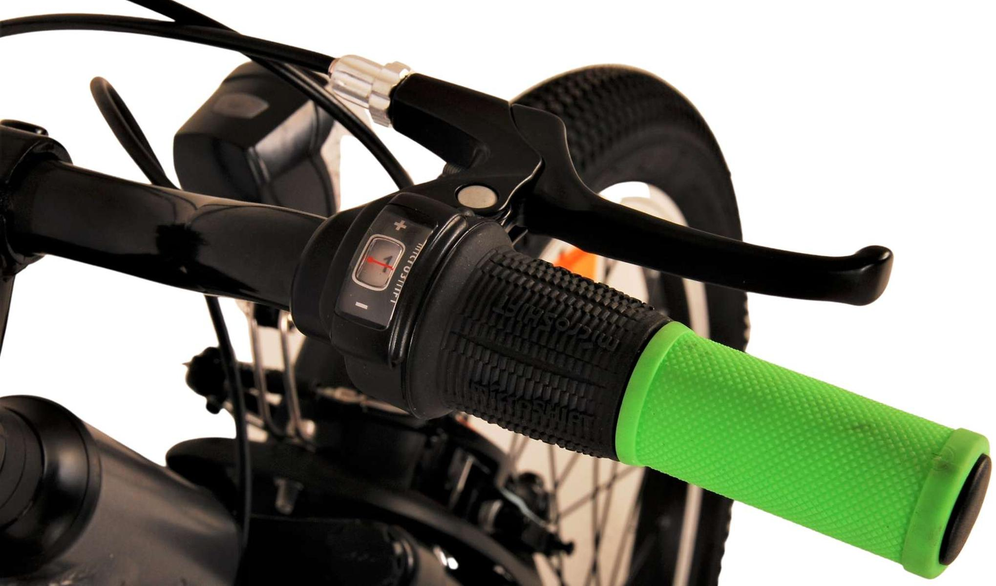 Nahaufnahme eines Fahrradlenkers mit grünem Griff und Gangschaltungsbedienung.